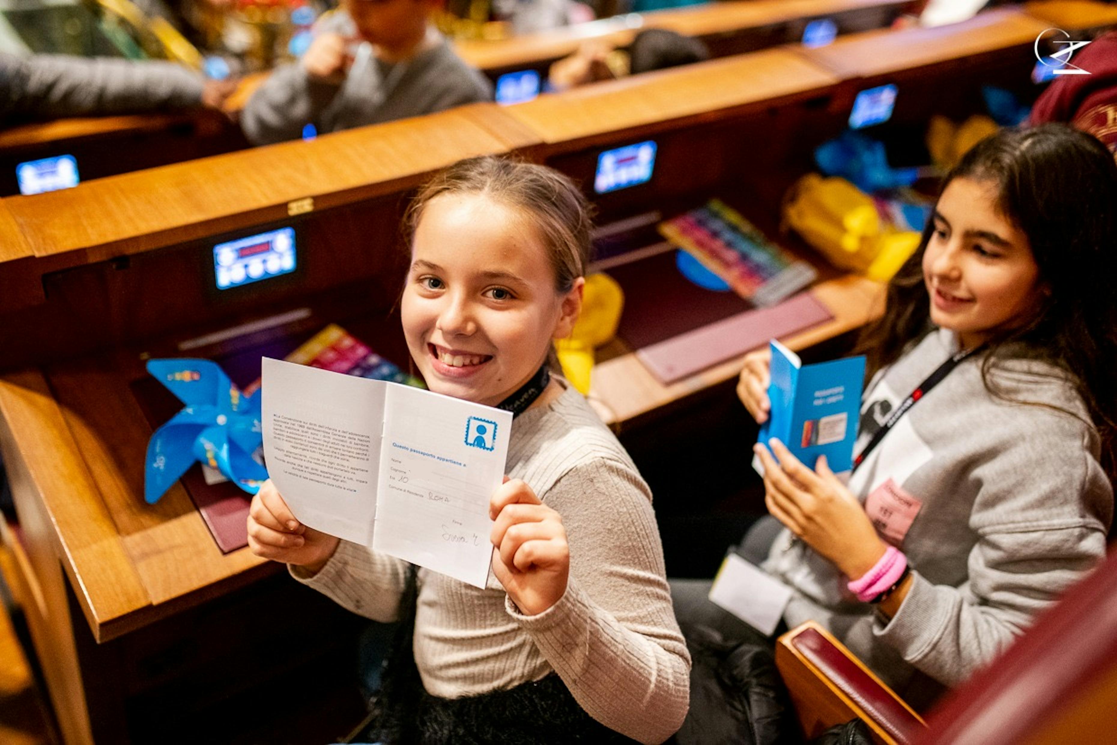 Una bambina mostra il Passaporto dei Diritti, pubblicato in occasione del 20 novembre 2019