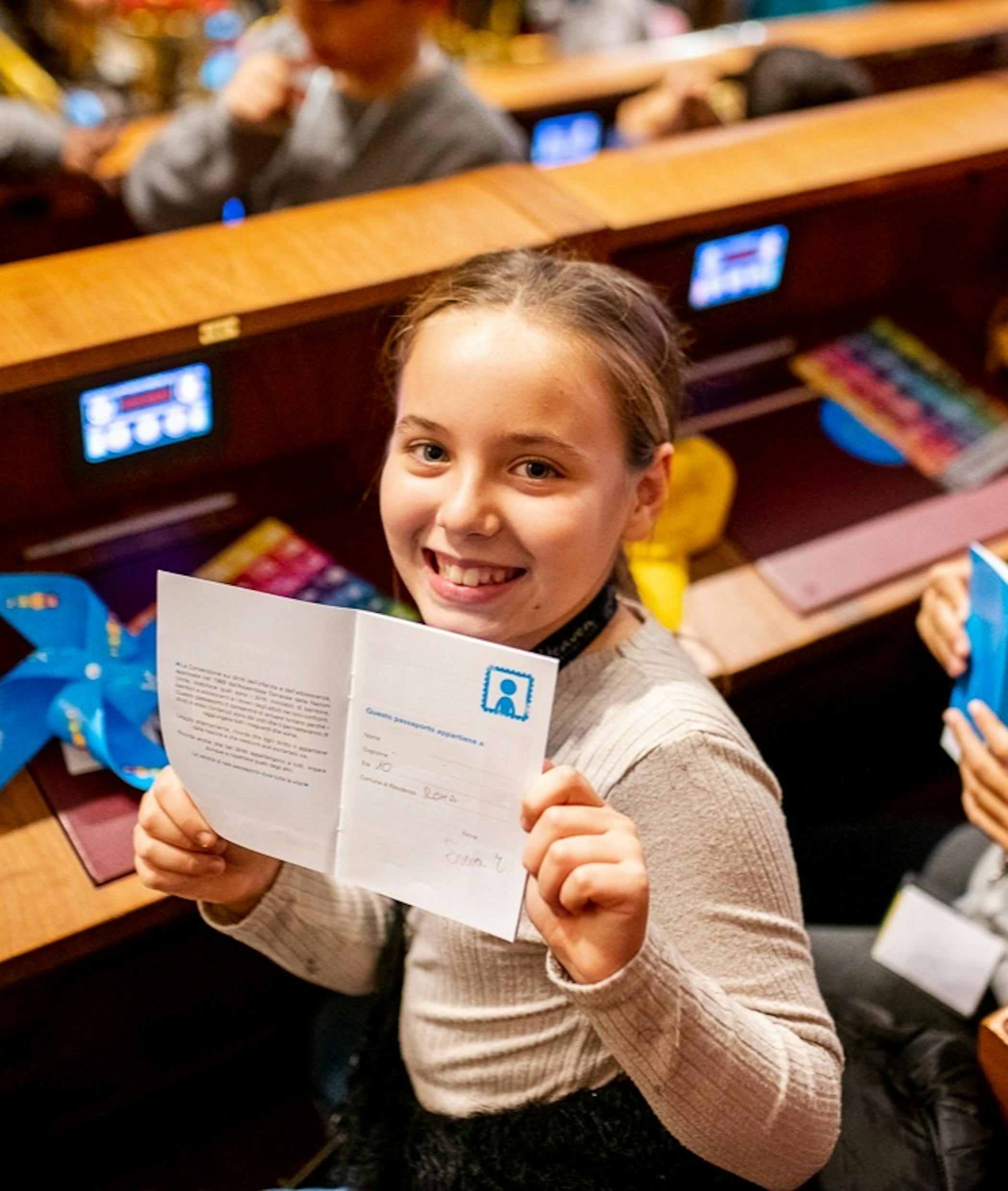 Una bambina mostra il Passaporto dei Diritti, pubblicato in occasione del 20 novembre 2019