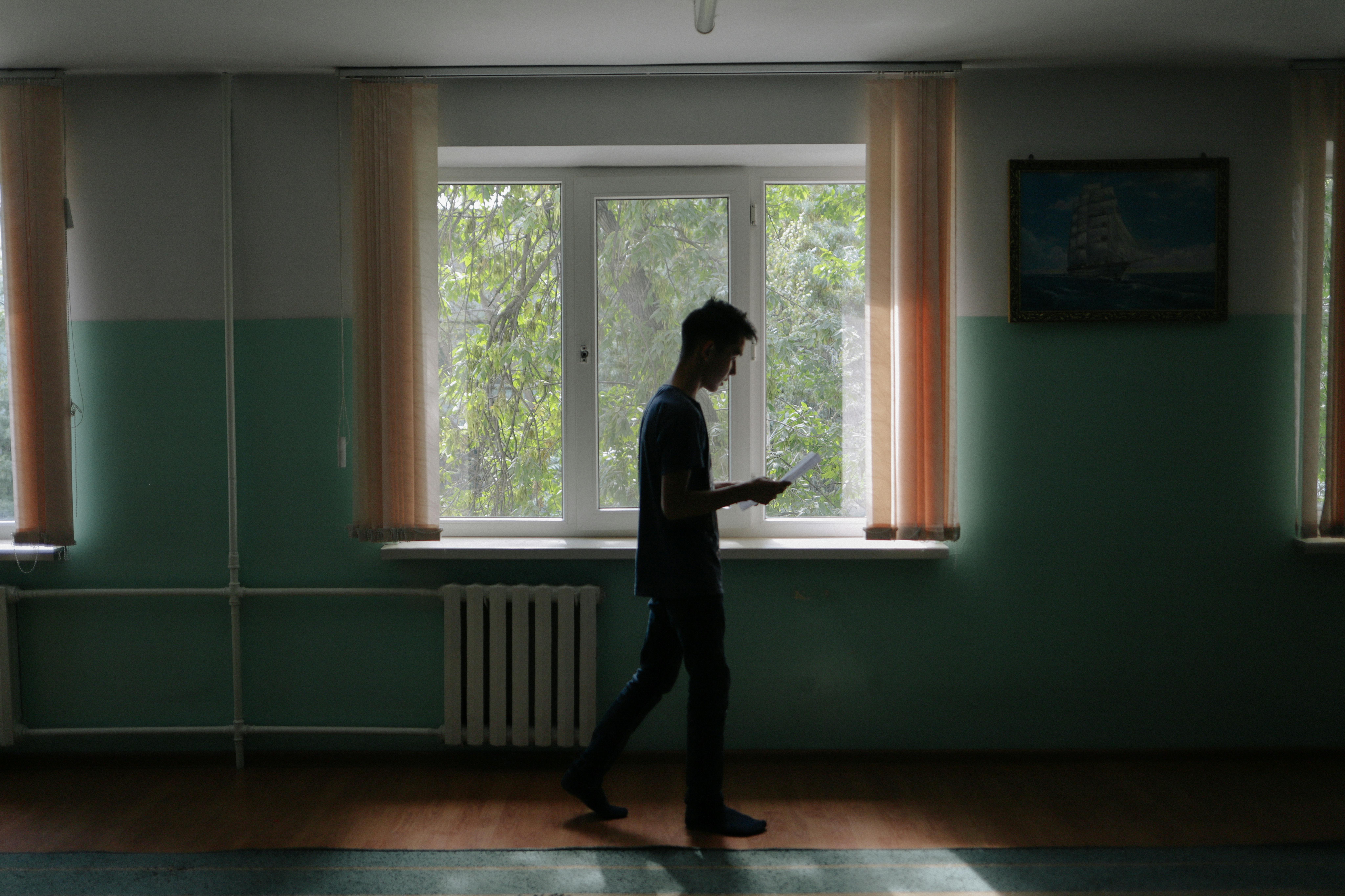 Baurzhan, 14 anni, guarda il suo telefono mentre si trova a scuola a Shymkent, Kazakhstan