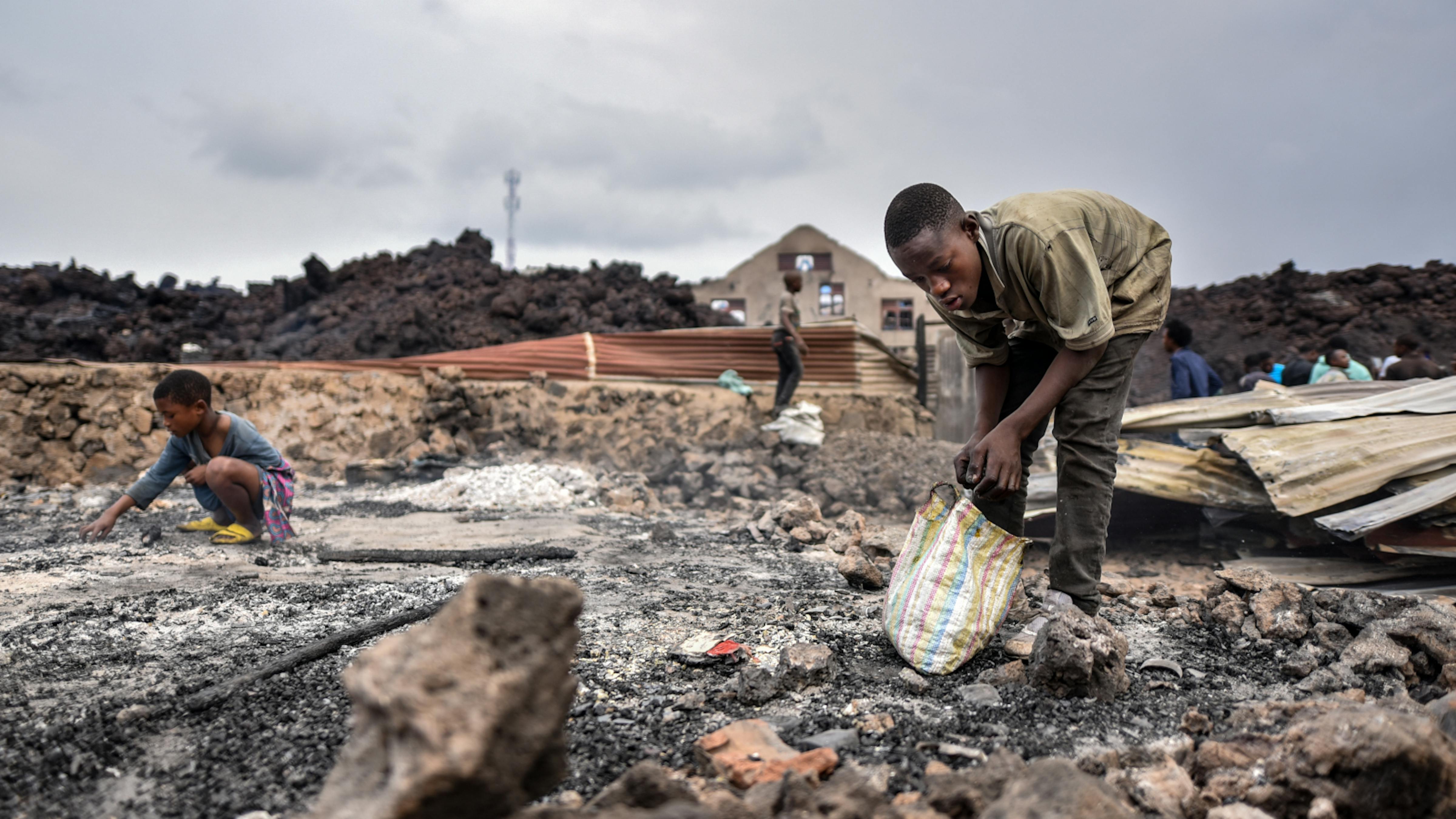 Alcuni bambini raccolgono ciò che resta delle loro cose dopo l'eruzione del vulcano Nyiragongo a Goma