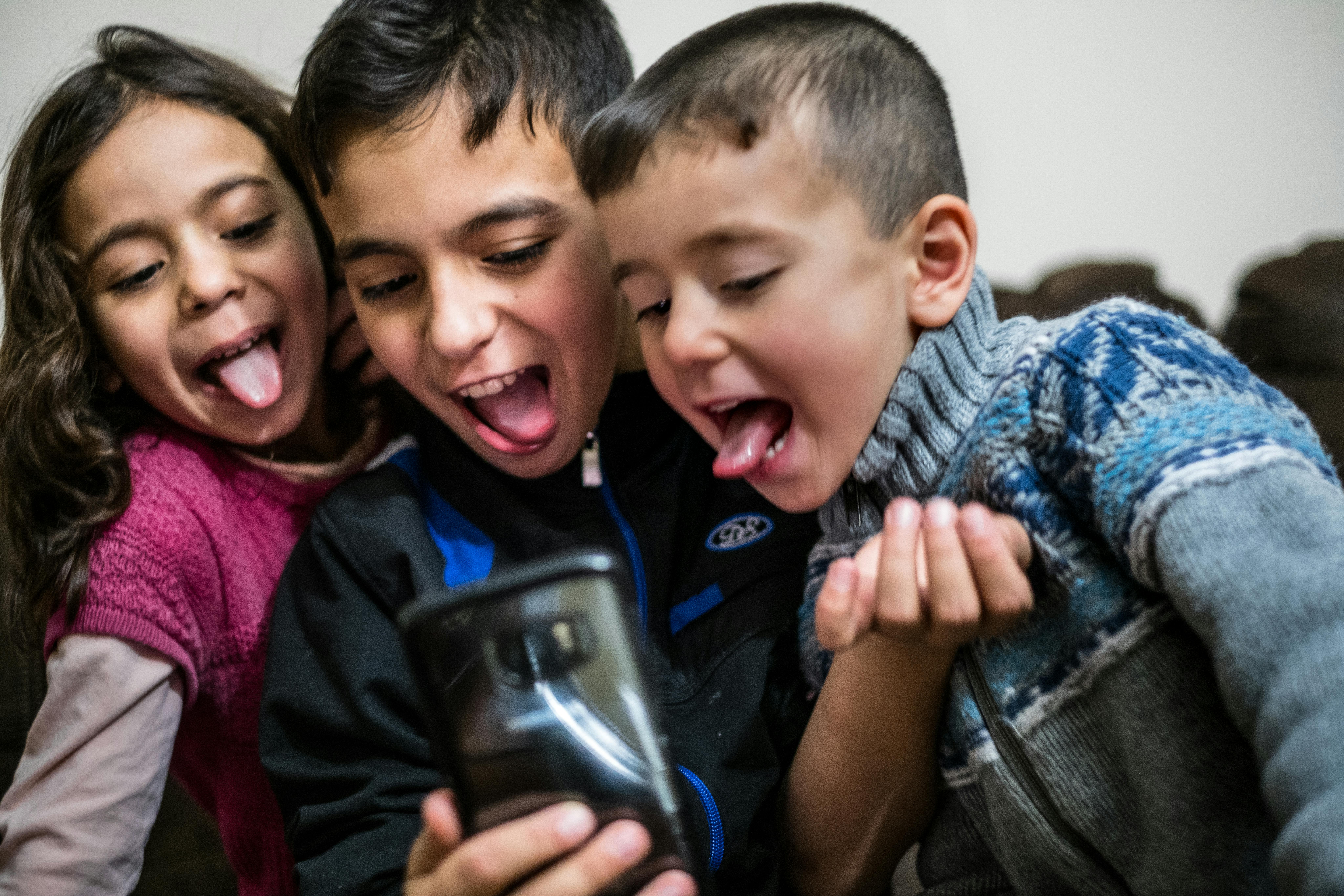 Canada, tre bambini giocano con i filtri di snapchat con lo smartphone