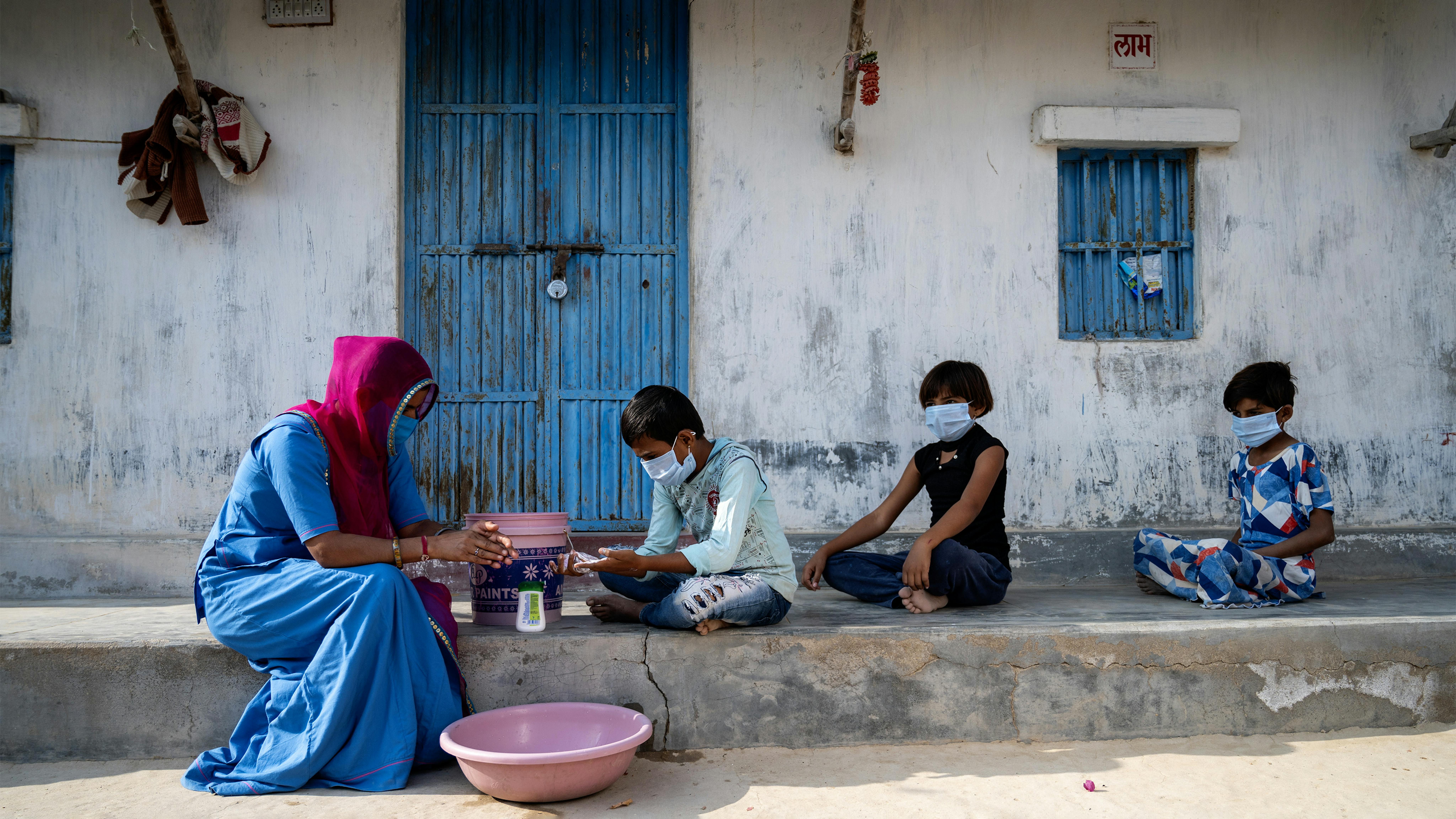 India,  Asha Laxmi, un operatore sociale.  conduce una sessione di lavaggio delle mani nelle case del villaggio durante la pandemia di covid 19