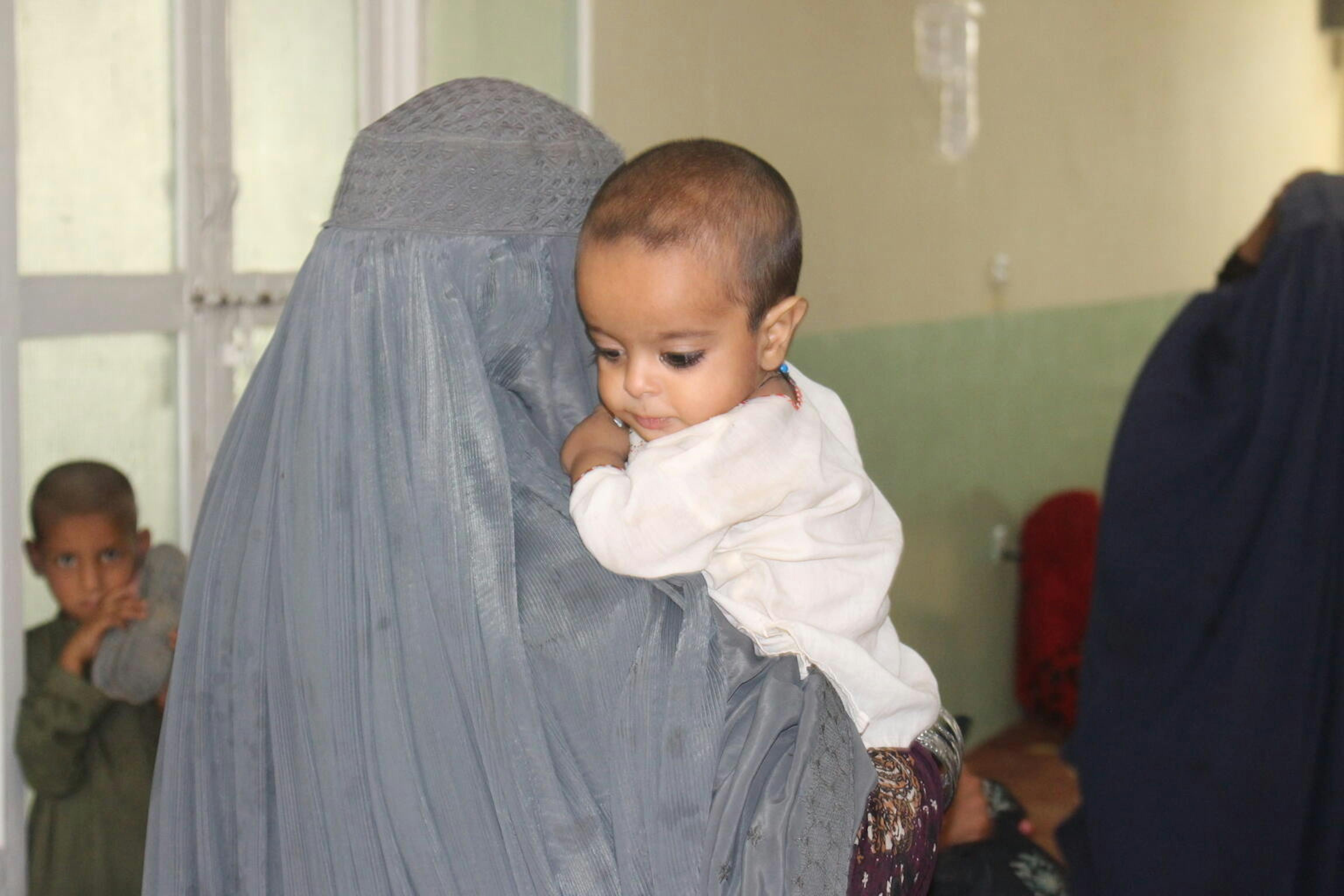 Rafiullah, 2 anni, e la sua mamma Rahima, aspettano di ricevere le cure all'ospedale presso il campo di Haji, per sfollati interni, vicino a Kandahar, sud dell'Afghanistan. 5 agosto 2021