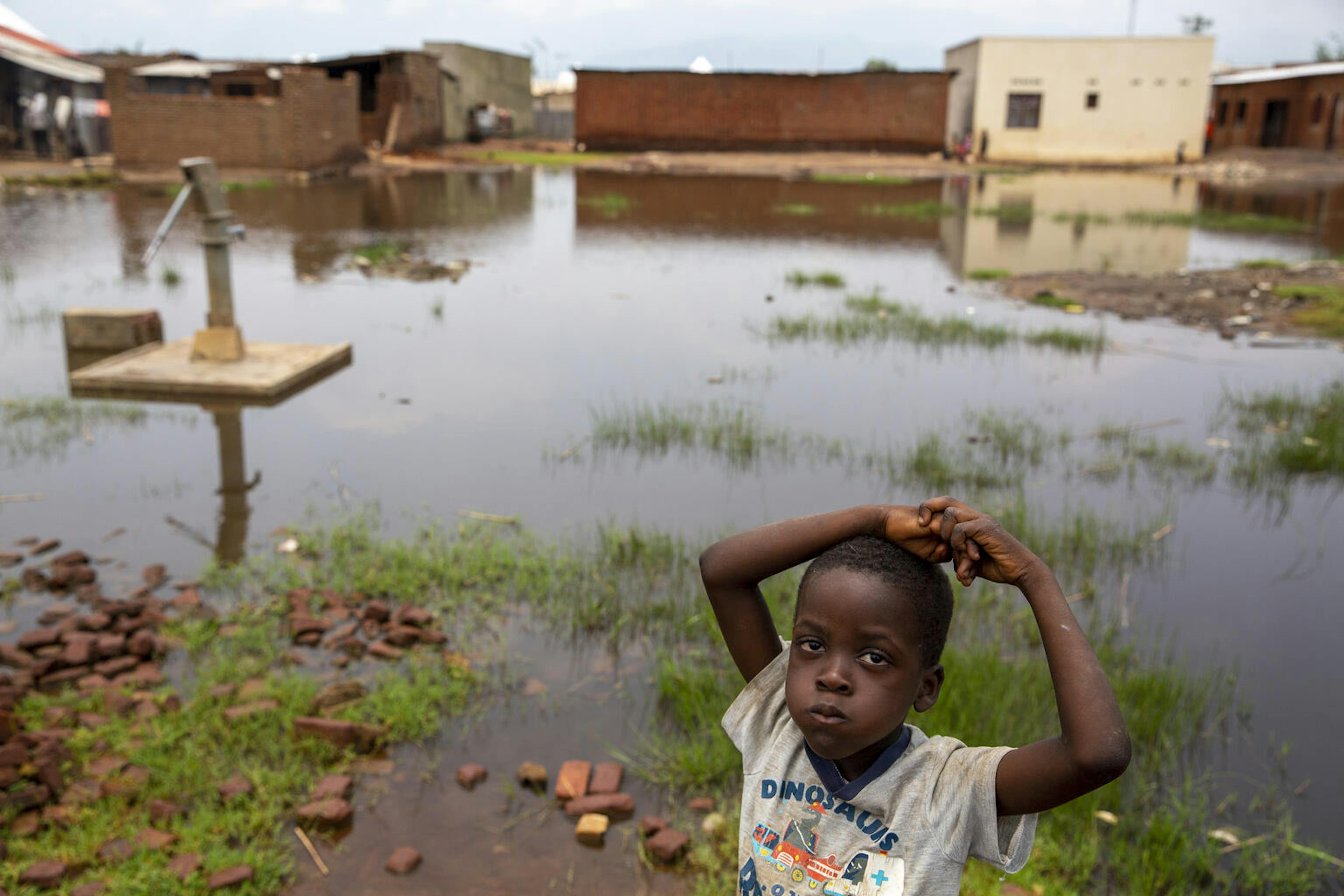 Un bambino vicino a una pompa per l'acqua sommersa a causa delle alluvioni, a Gatumba, vicino a Bujumbura in Burundi. 5 marzo 2021