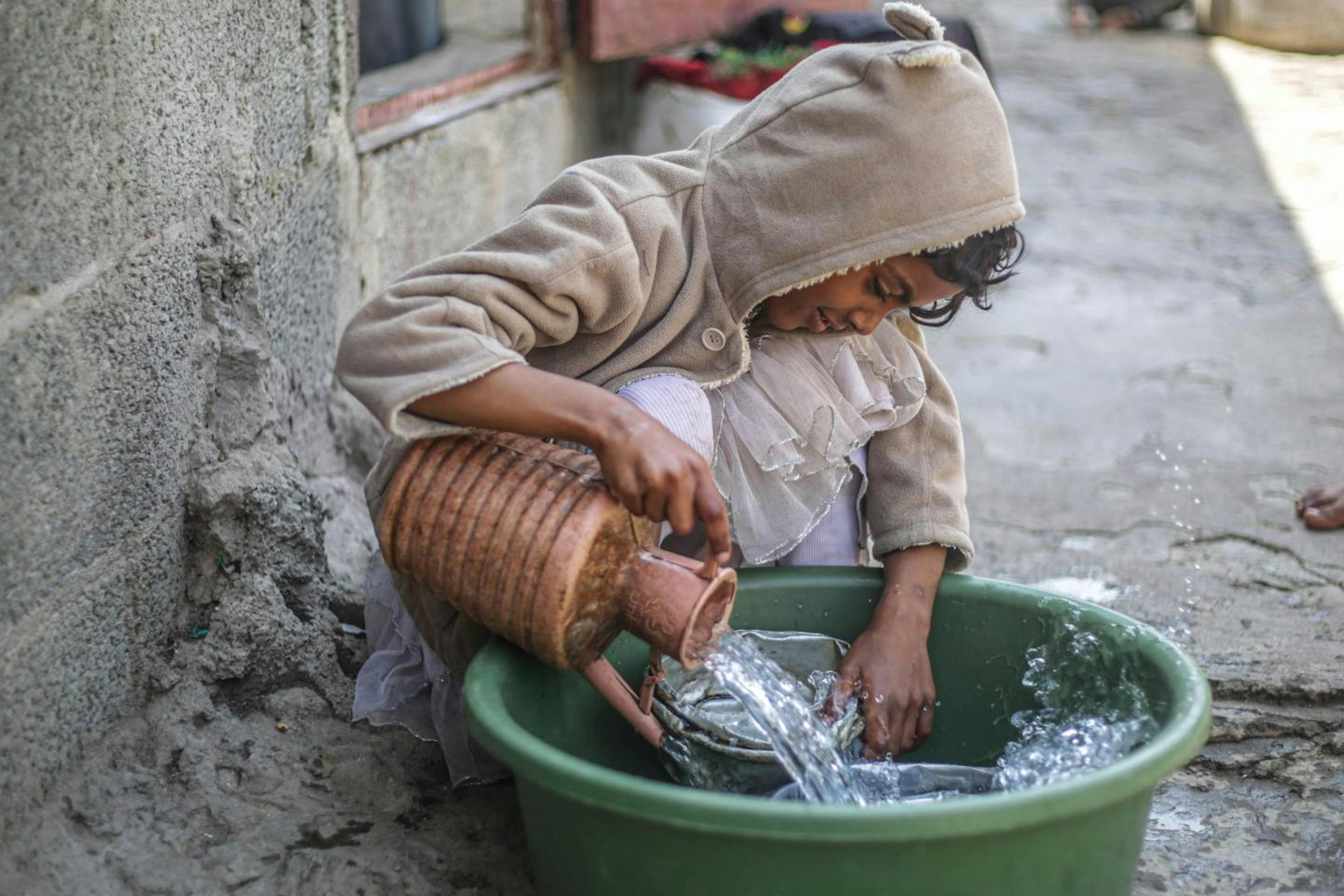 Yemen: Sara Fawzi, 14 anni, in un campo per sfollati con la sua famiglia lava i piatti. L'acqua è tornata disponibile grazie al ripristino del pozzo con il sostegno dell'UNICEF