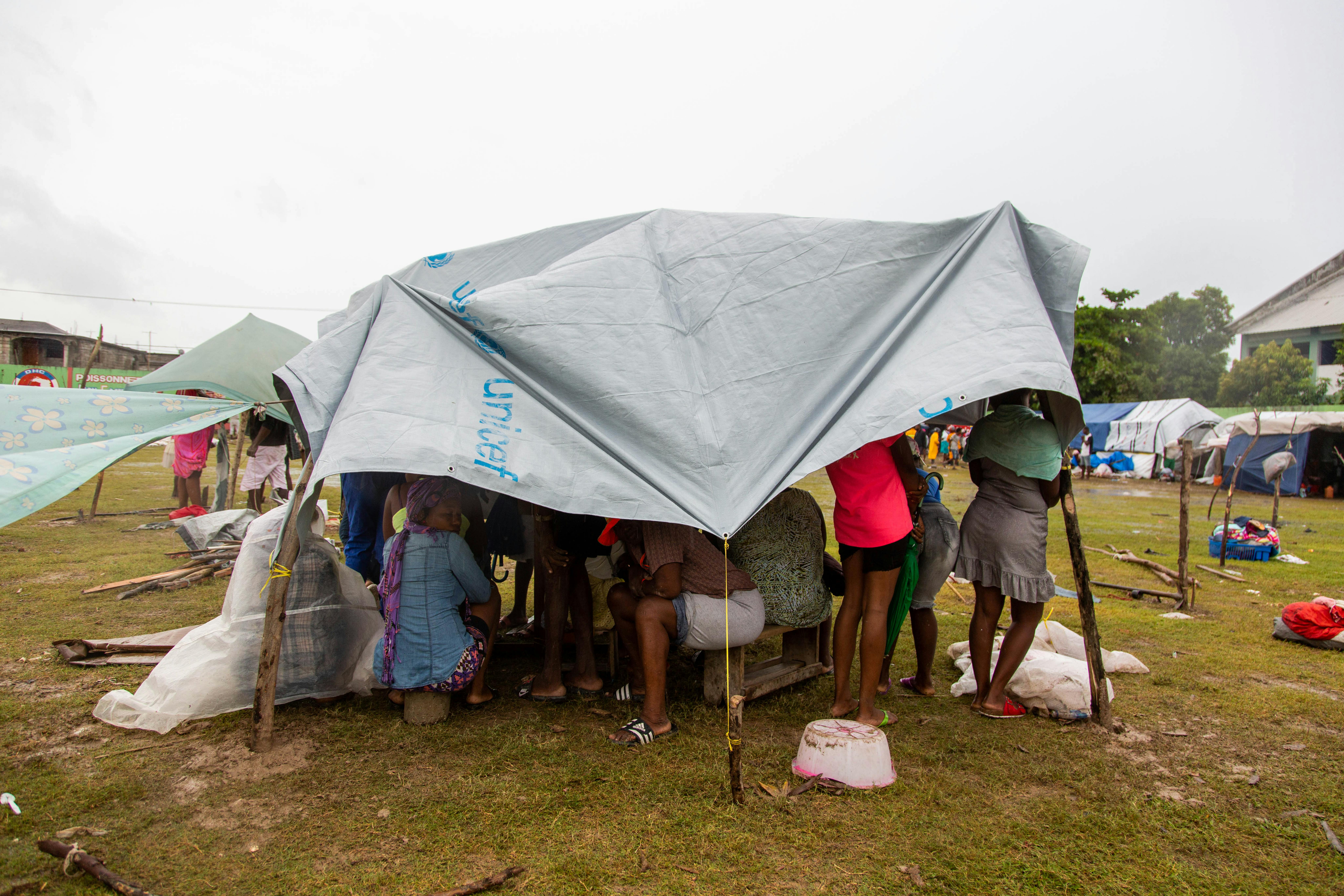 Les Cayes, Haiti: alcune persone sfollate a causa del terremoto si rifugiano sotto i teloni forniti dall'UNICEF. Oltre ad aver perso la casa a complicare tutto è arrivata la tempesta tropicale Grace
