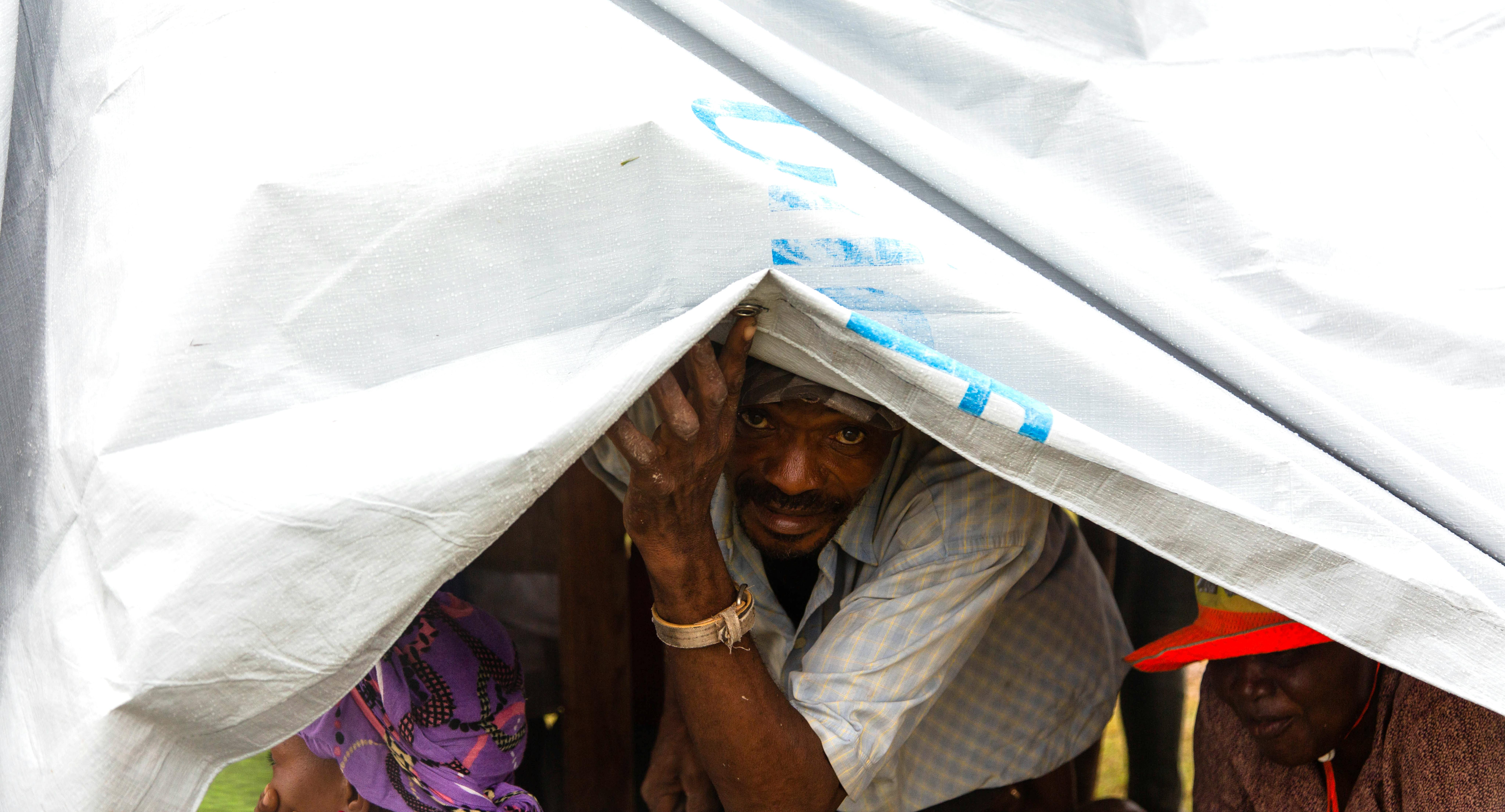 Uno dei residenti di Les Cayes, sfollato a causa del terremoto, si rifugia dalla tempesta tropicale Grace nelle tende fornite dall'UNICEF sul campo di calcio dello Stade des Gabio a Les Cayes, ad Haiti.