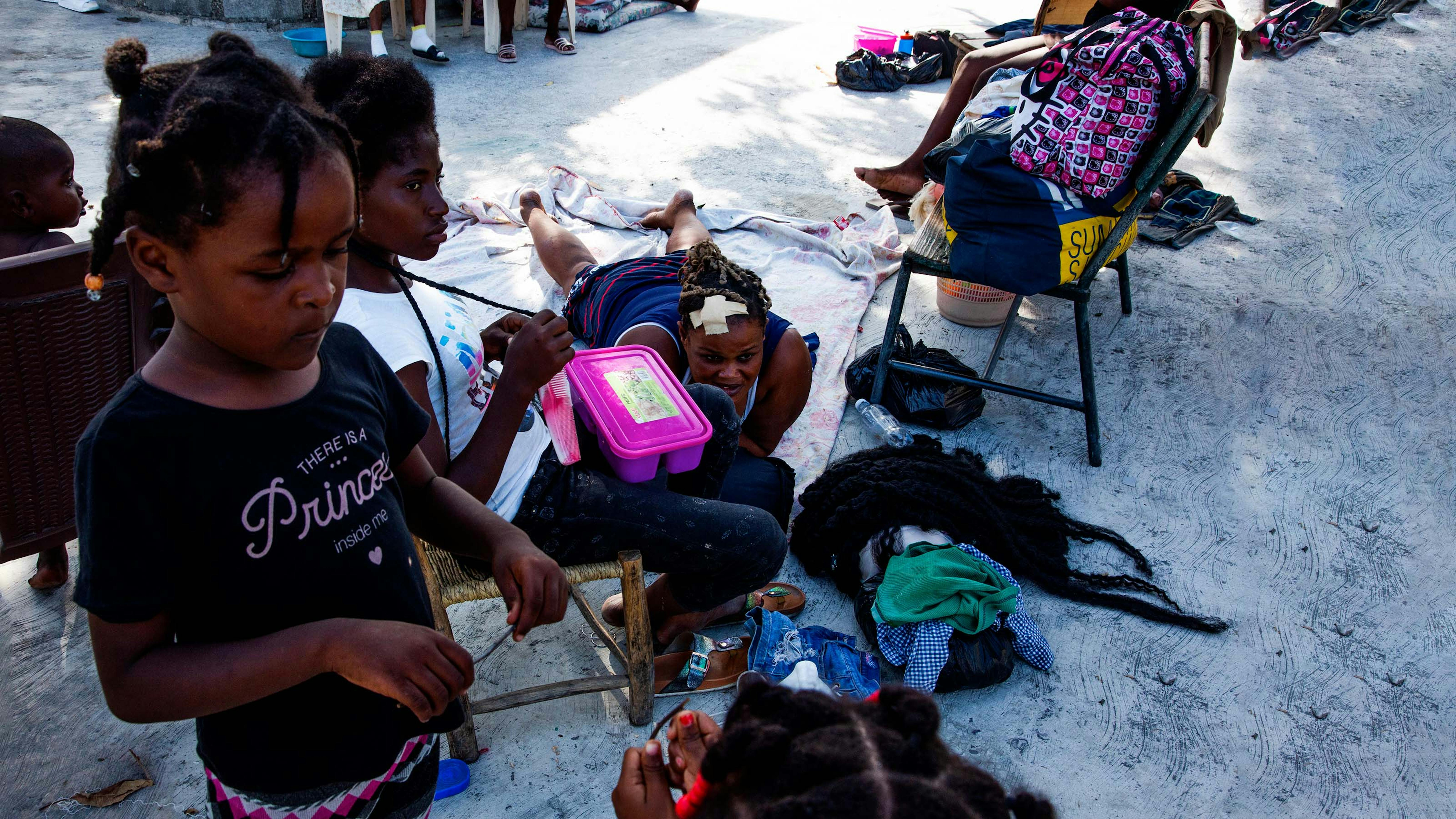 Haiti, una famiglia in attesa fuori del centro sanitario di Las Cayes