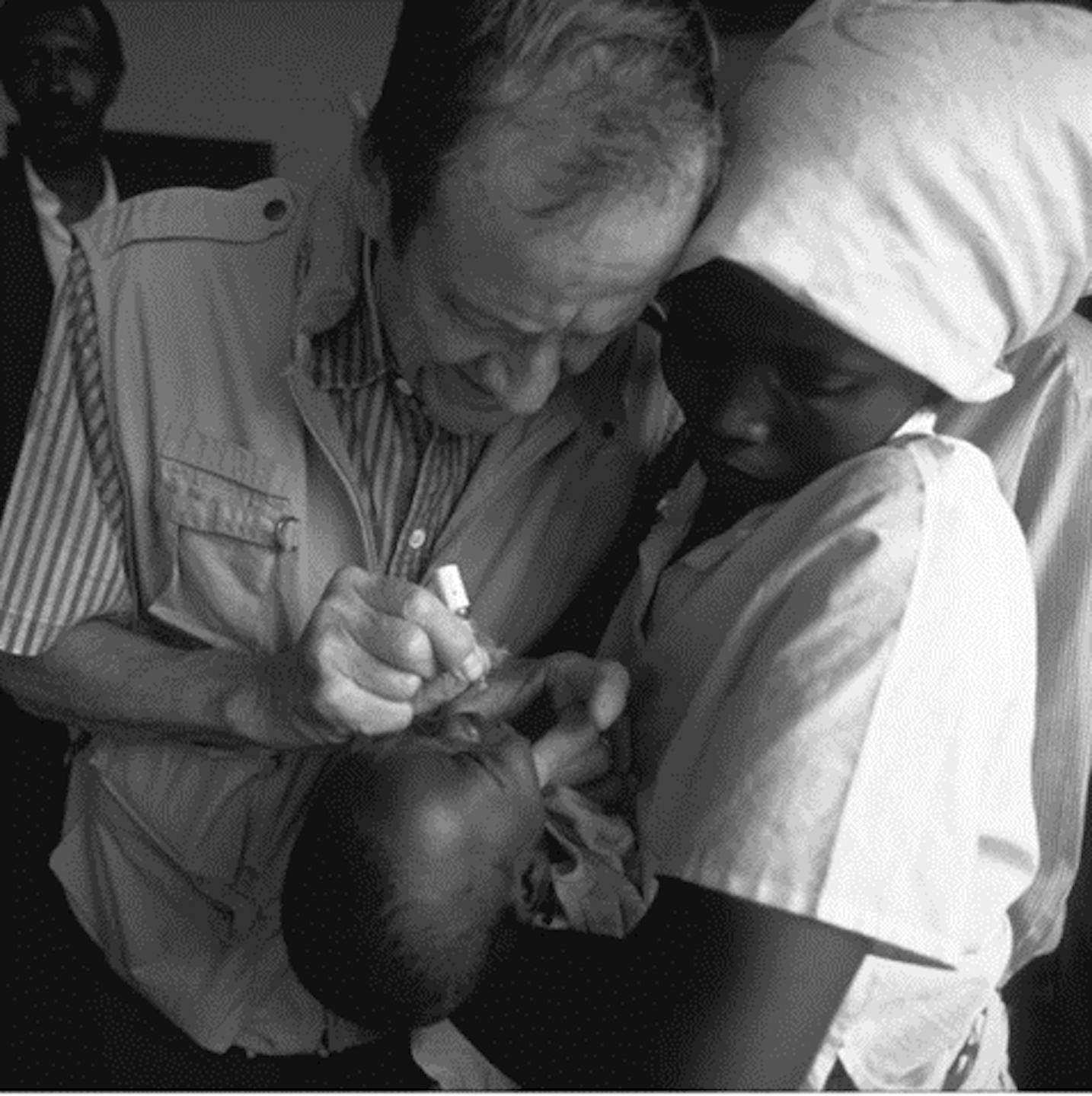 1980, il Direttore Generale James P. Grant somministra  una goccia di vaccino antipolio a un neonato. Siamo a  Myamata, a sud-est di Kigali, Ruanda.