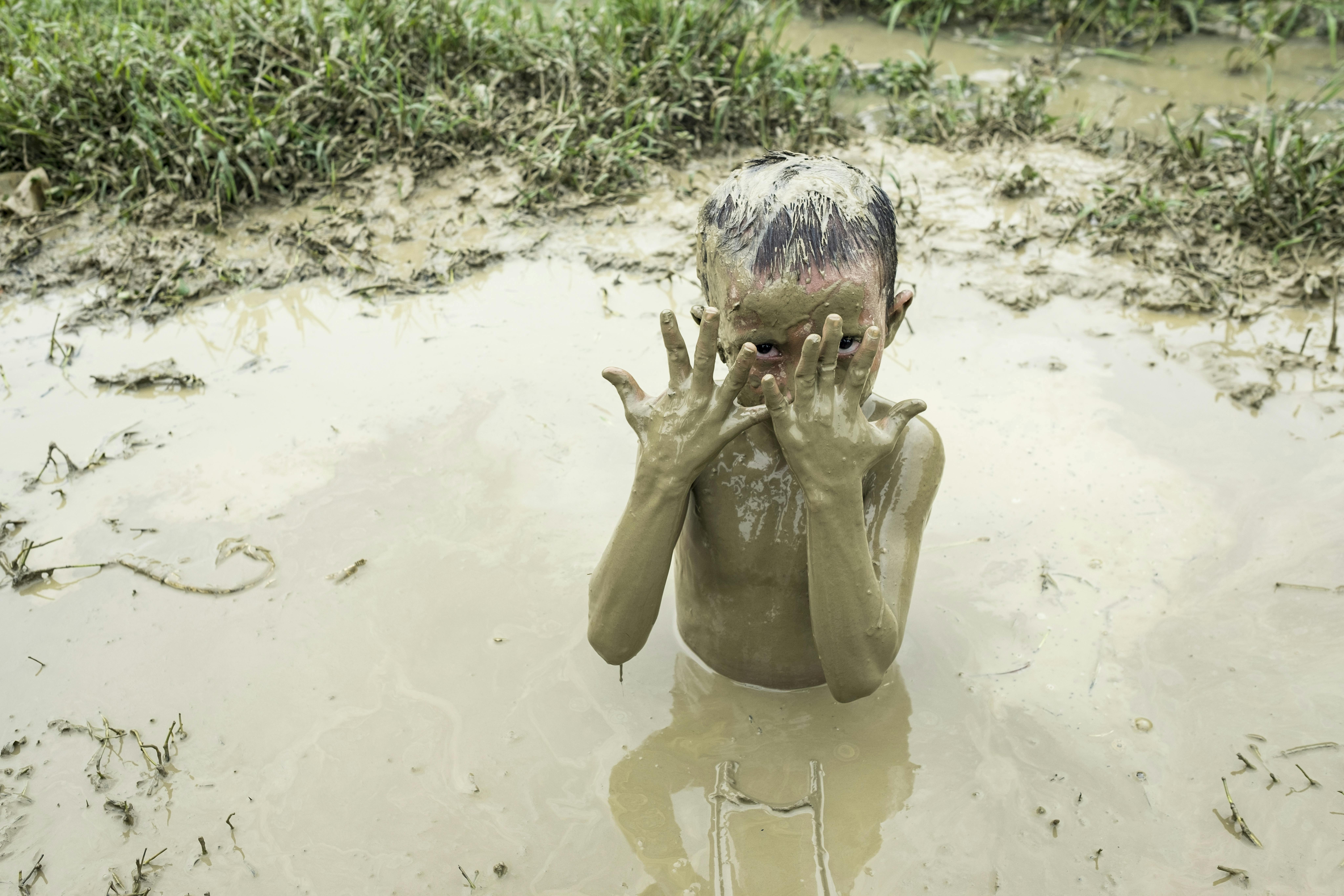 Abu Omair, 5 anni, gioca nel fango in un campo Rohingya a Cox's Bazar. Le piogge monsoniche hanno creato zone fangose in tutti i campi.