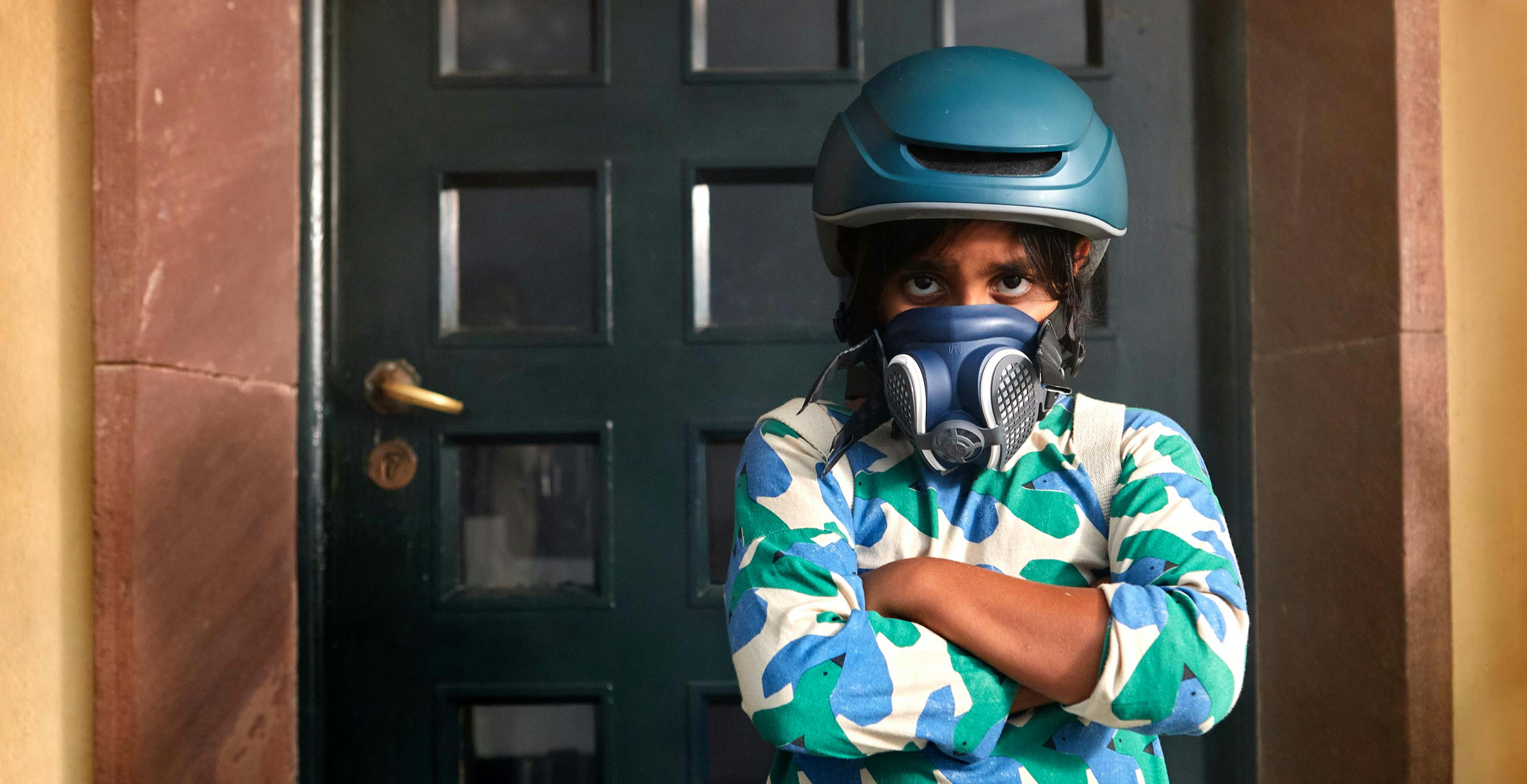 Spagna, una ragazza indossa un casco da bici e una maschera antigas per rappresentare il futuro catastrofico che attende i bambini se l'emergenza climatica dovesse peggiorare 