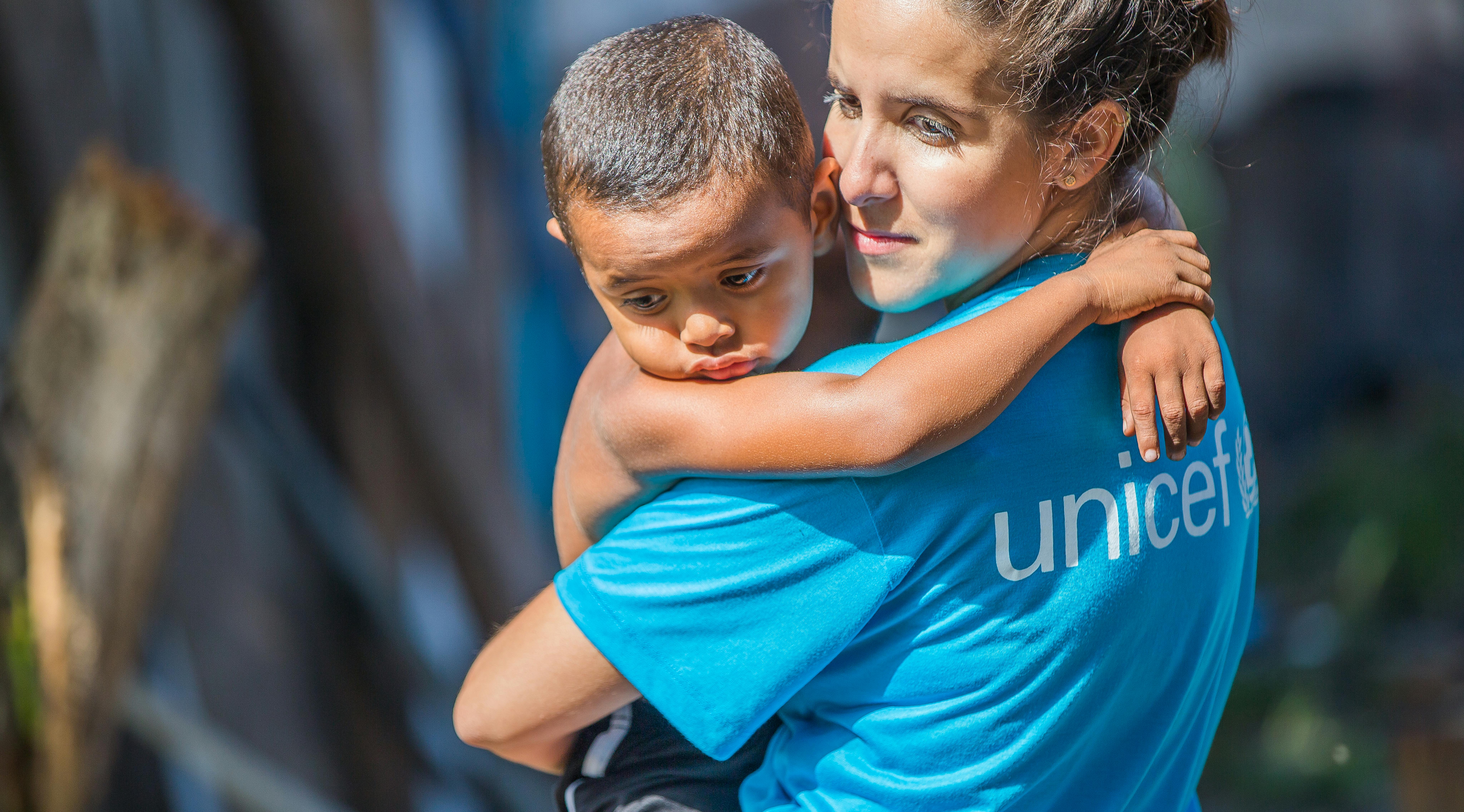 Brasile, un'operatrice UNICEF tiene in braccio un bambino. 