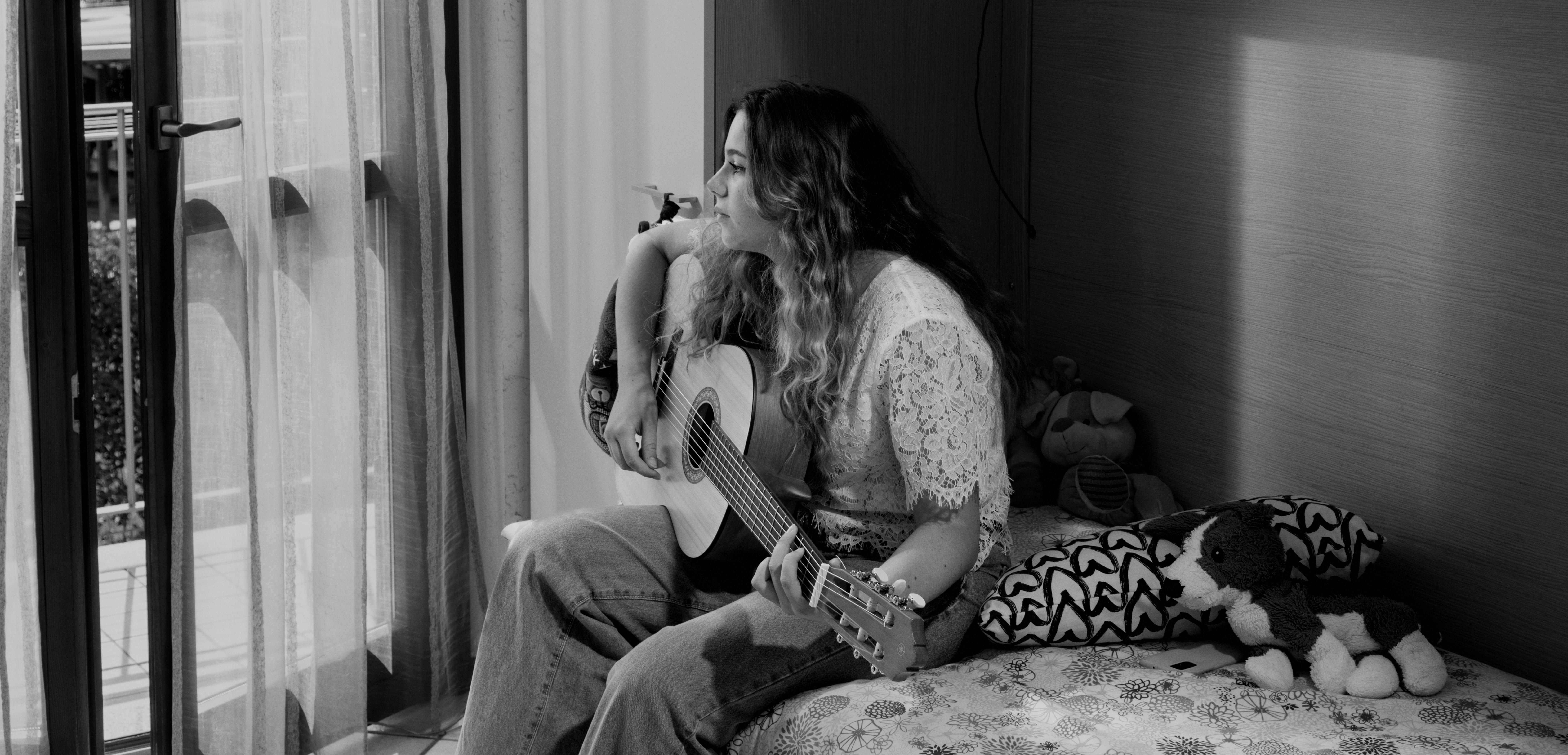 Anna, adolescente italiana, suona la chitarra nella sua stanza durante la pandemia da COVID-19.