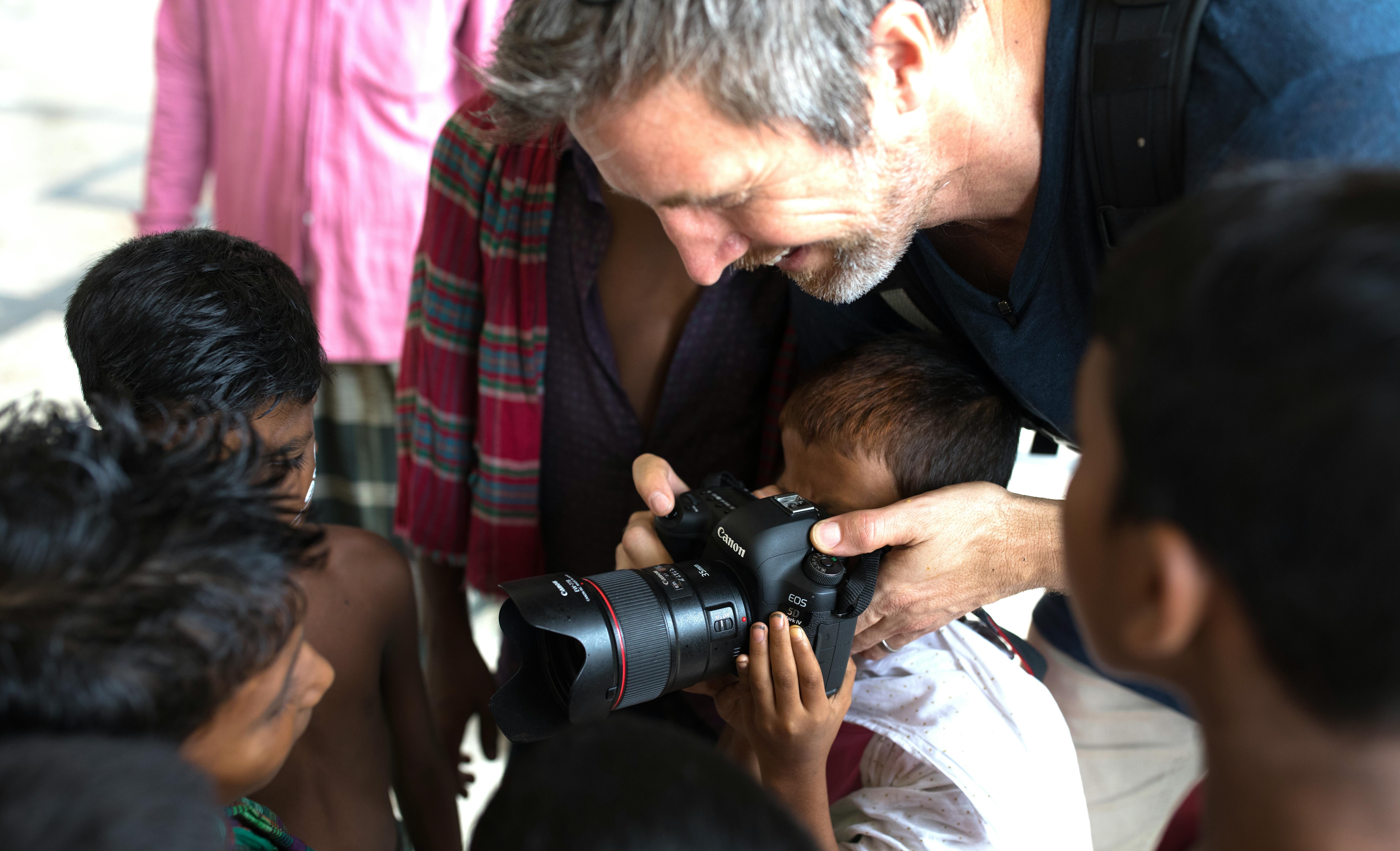 Bangladesh, Simon Lister mostra ai bambini come si vede attraverso le lenti della sua fotocamera