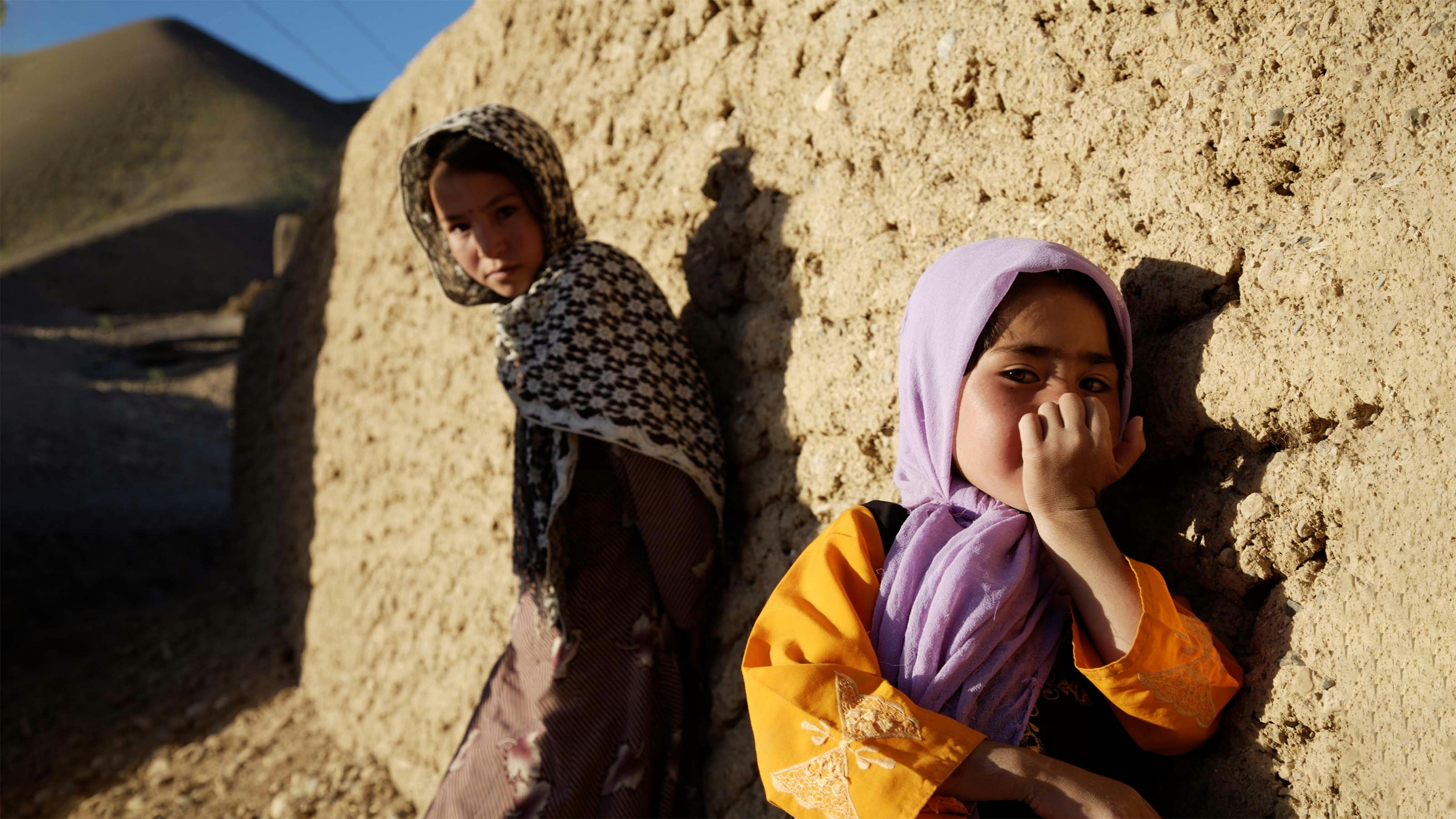 Due bambine si appoggiano a un muro a Bamyinan, Afghanistan