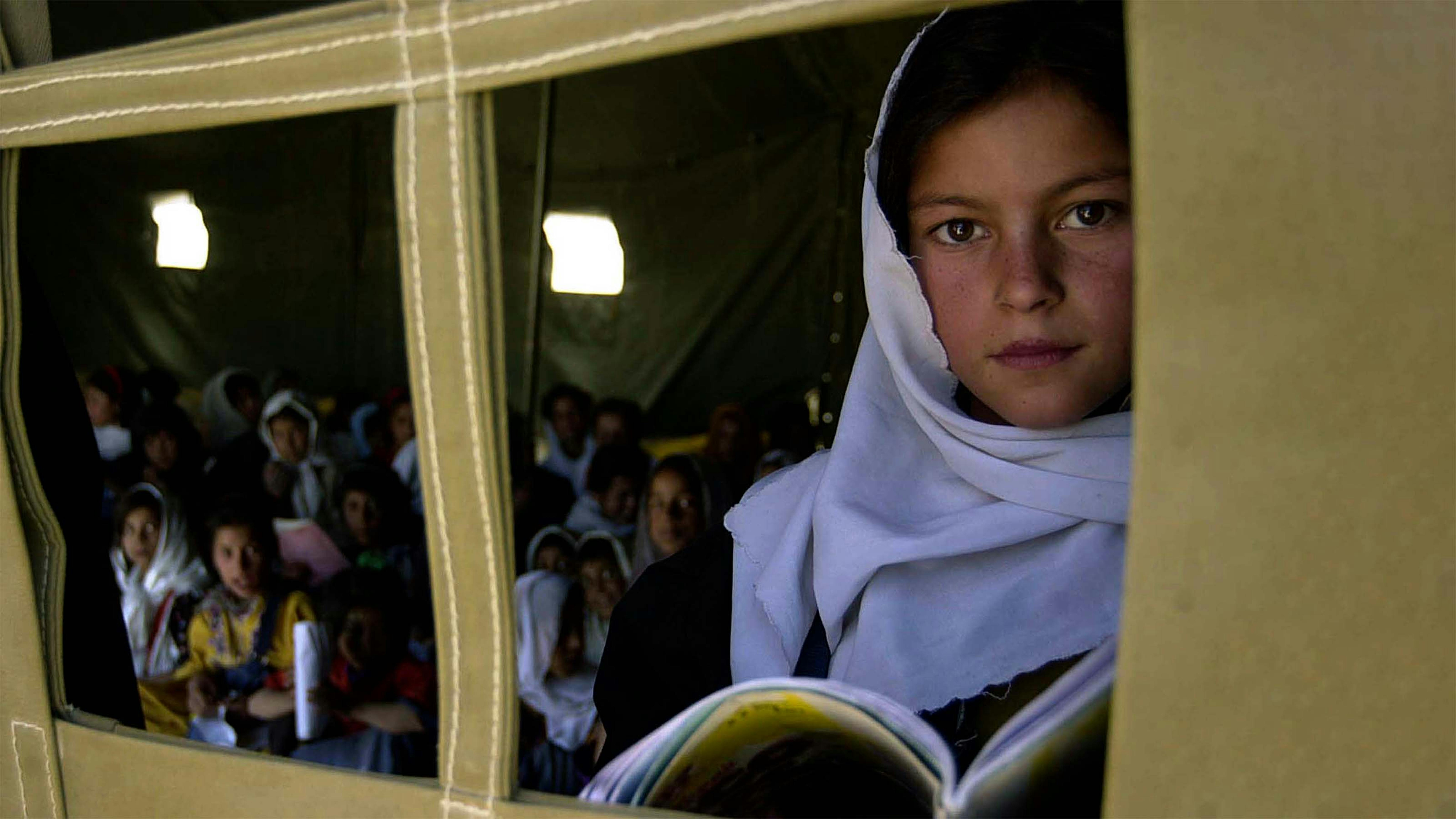 Una ragazza guarda fuori dalla finestra della scuola media Khawaja Rowash a Kabul, oggi in Afganistan le ragazze della sua età non possono più andare a scuola