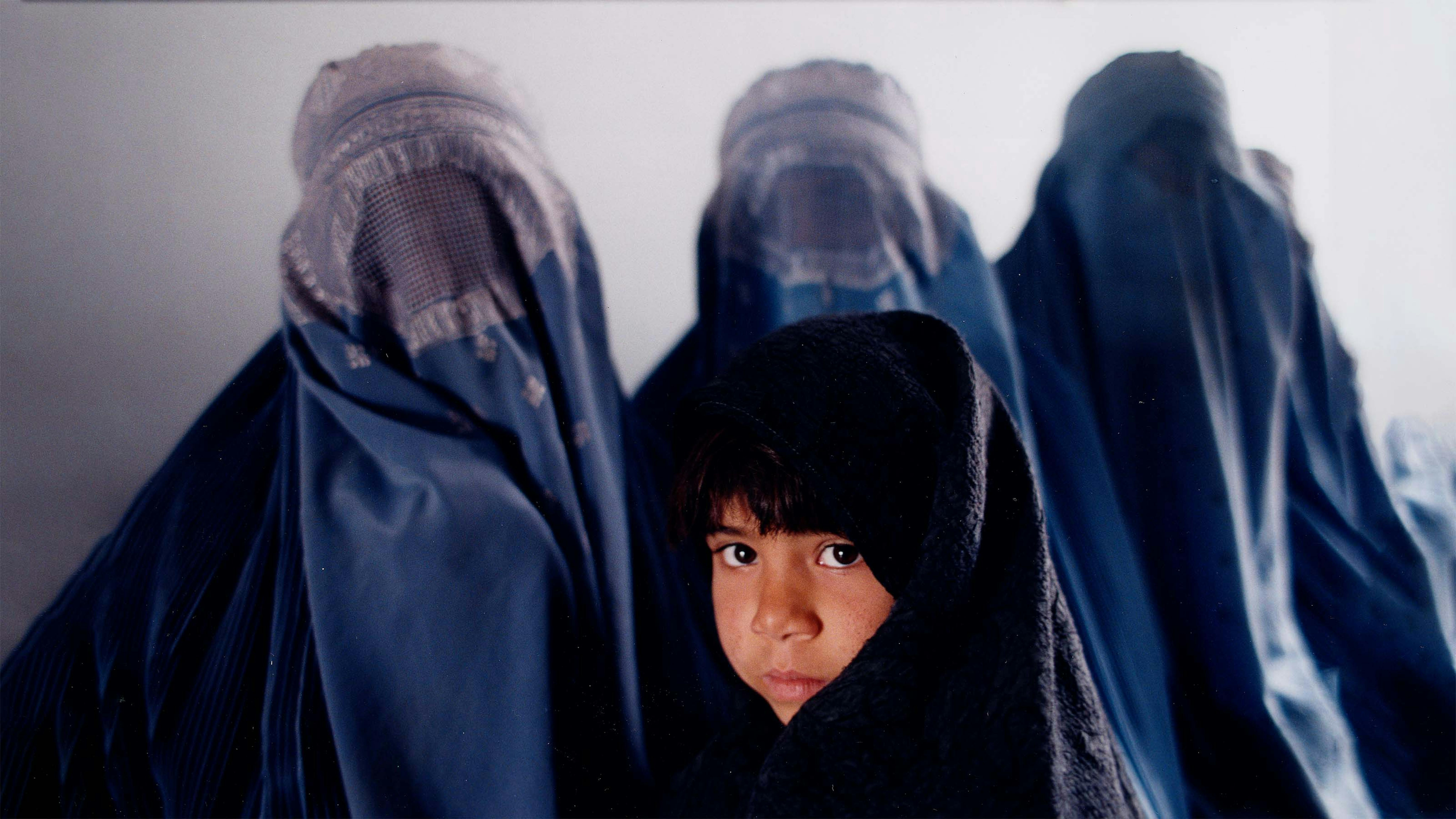 Una bambina afgana assieme a tre donne col burqua nell’anno 2000, durante il precedente governo dei talebani
