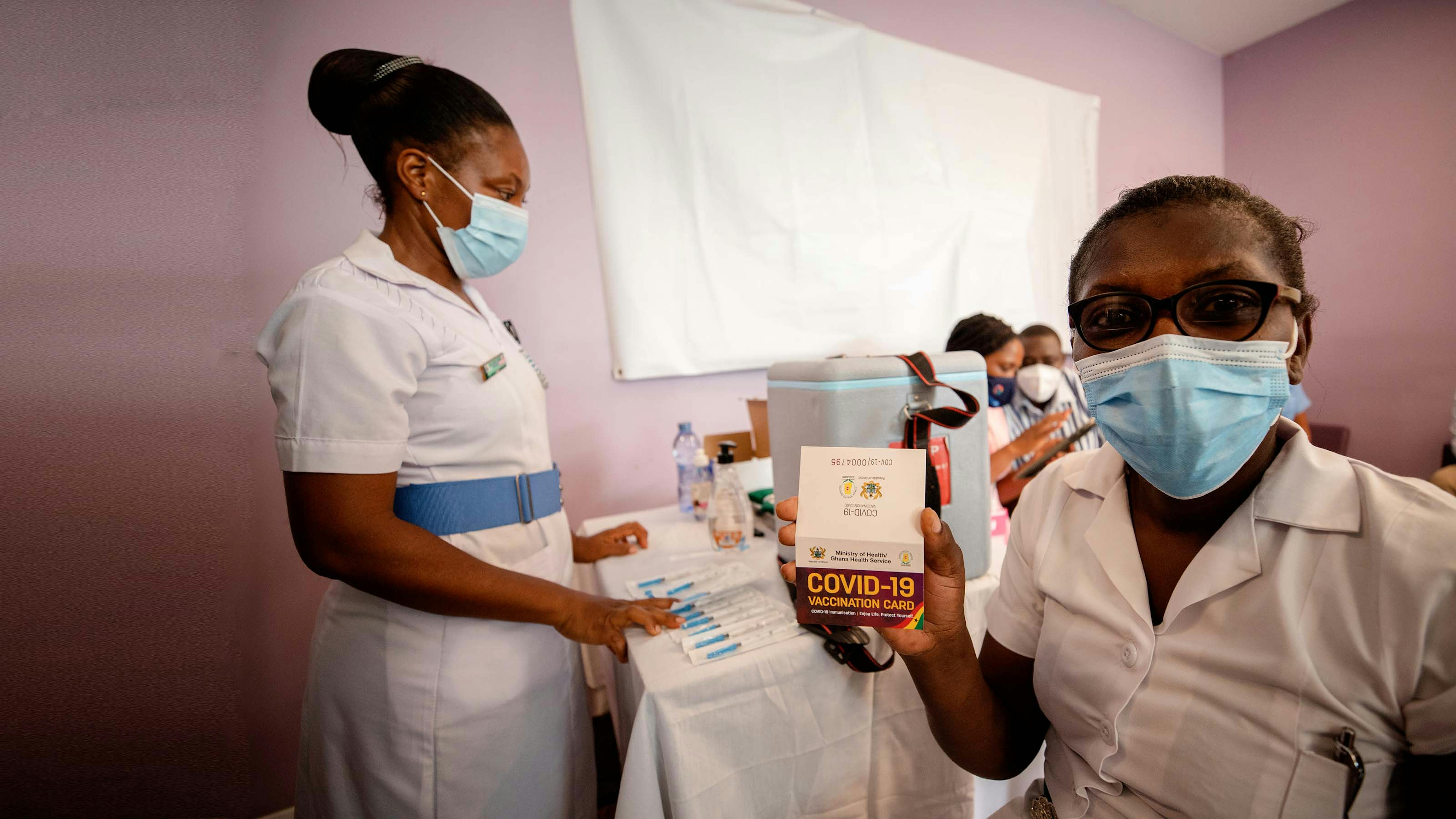 Ghana, l'infermiera Lucy mostra la card del vaccino anticovid ricevuta dopo la vaccinazione