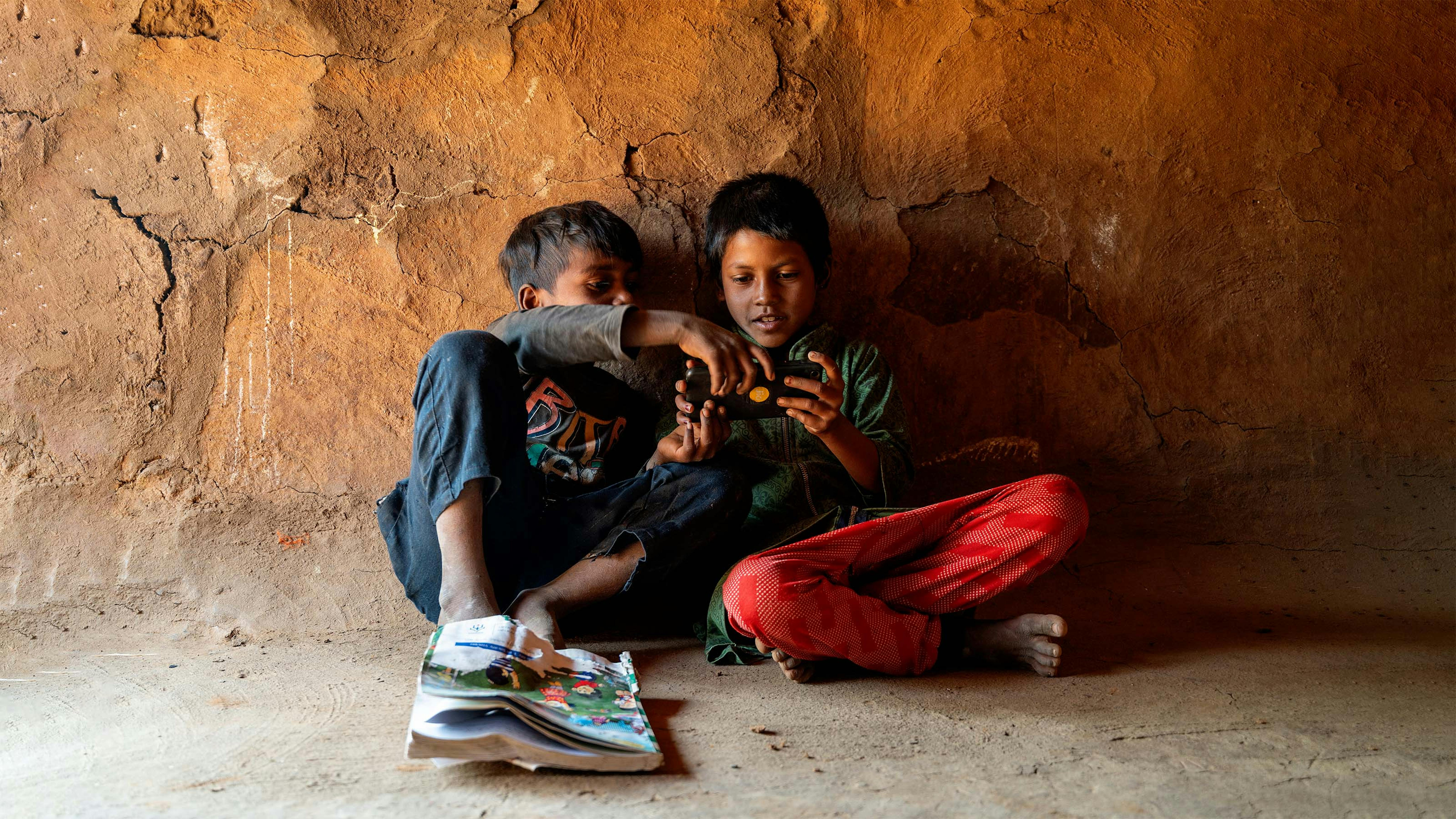 India, due bambini seguono la lezione da casa con lo smarthphone durante la pandemia da Covid