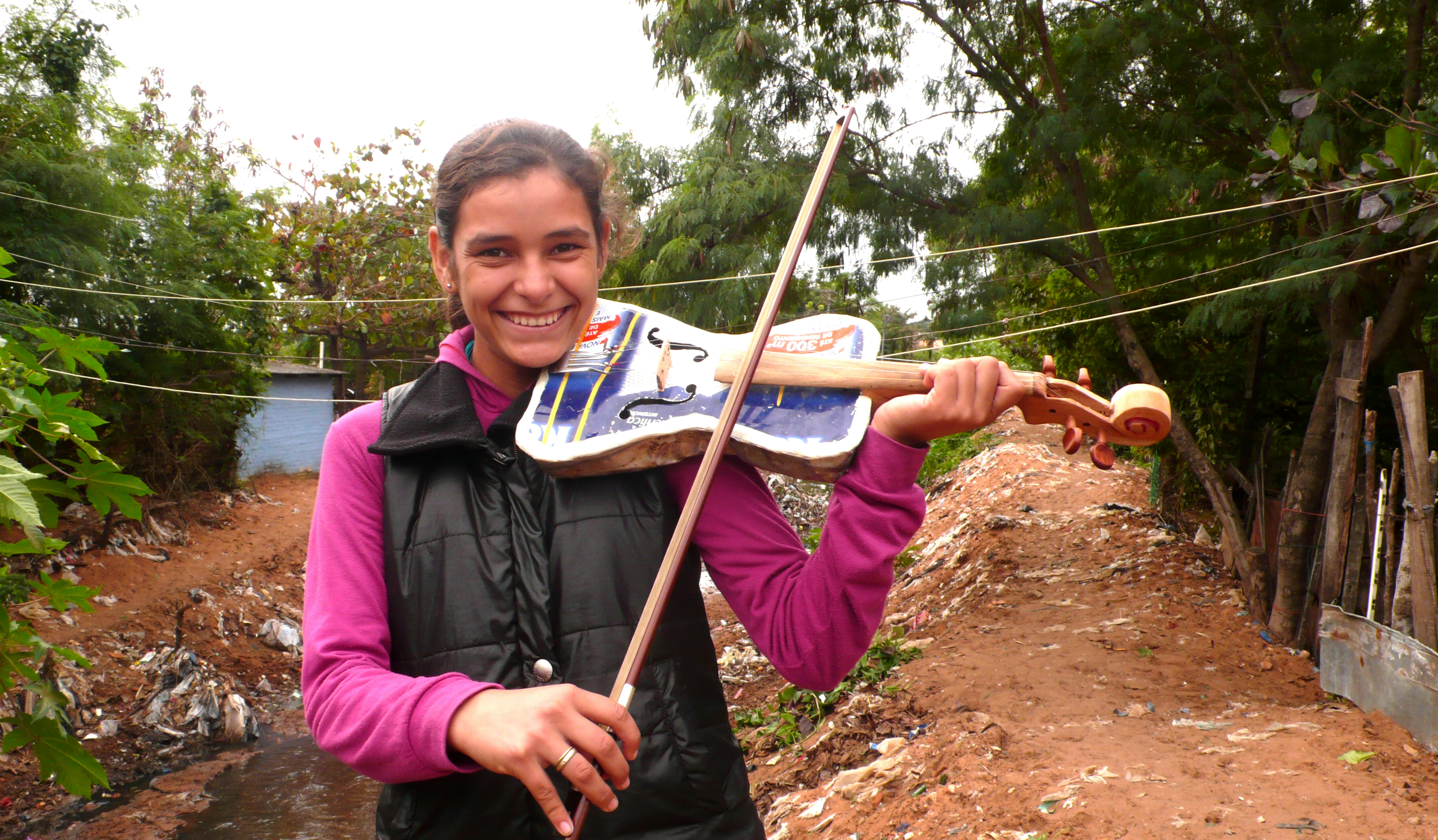 Una ragazza suona un violino realizzato con elementi riciclati. Fa parte dell'Orquesta Reciclada di Cateura Paraguay