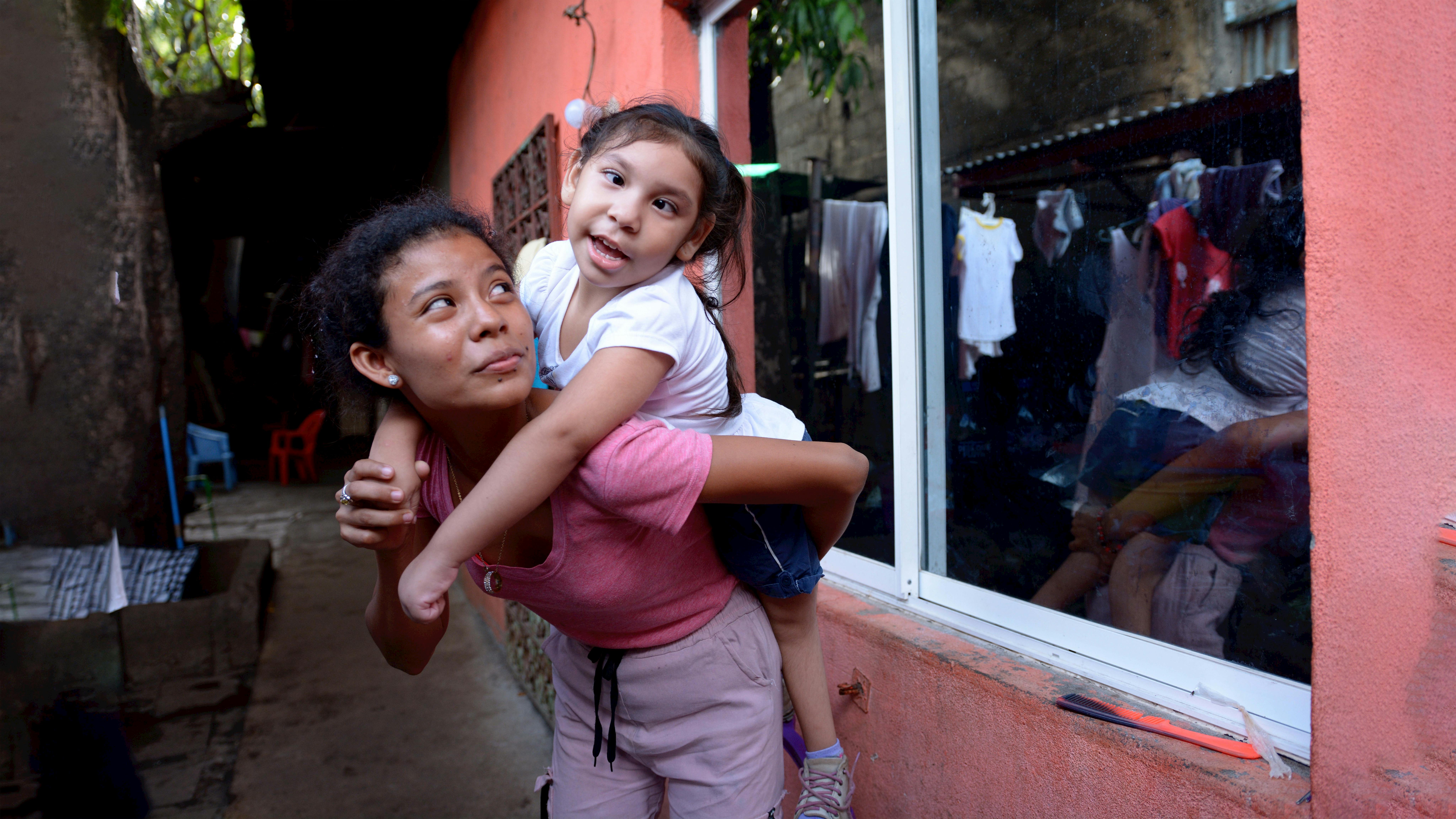 Nicaragua, una bambina gioca con una bambina disabile in attesa di un checkup medico