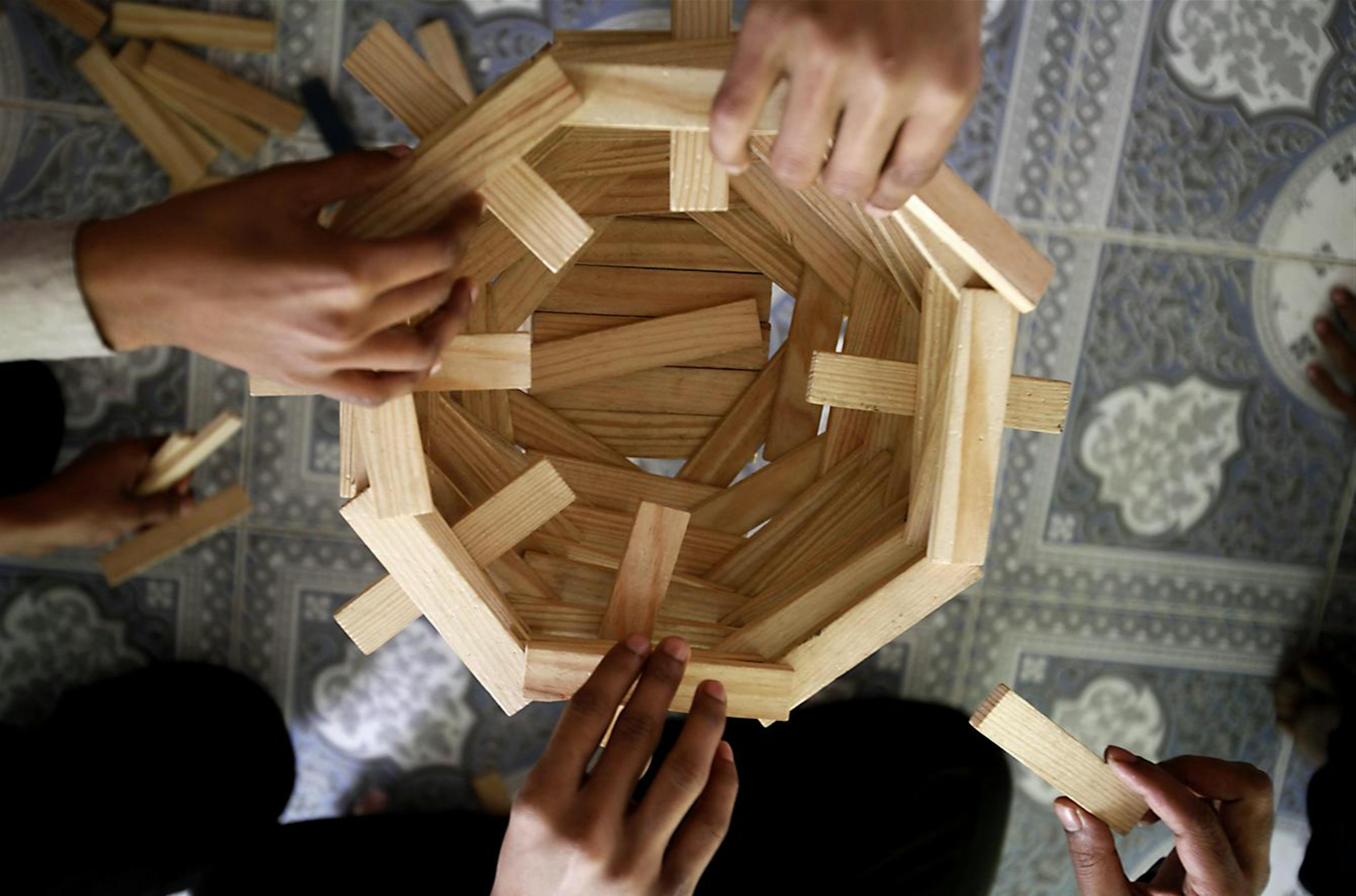 Ragazzi e ragazze creano una struttura con mattoncini di legno nell'ambito di un seminario organizzato dall'UNICEF
