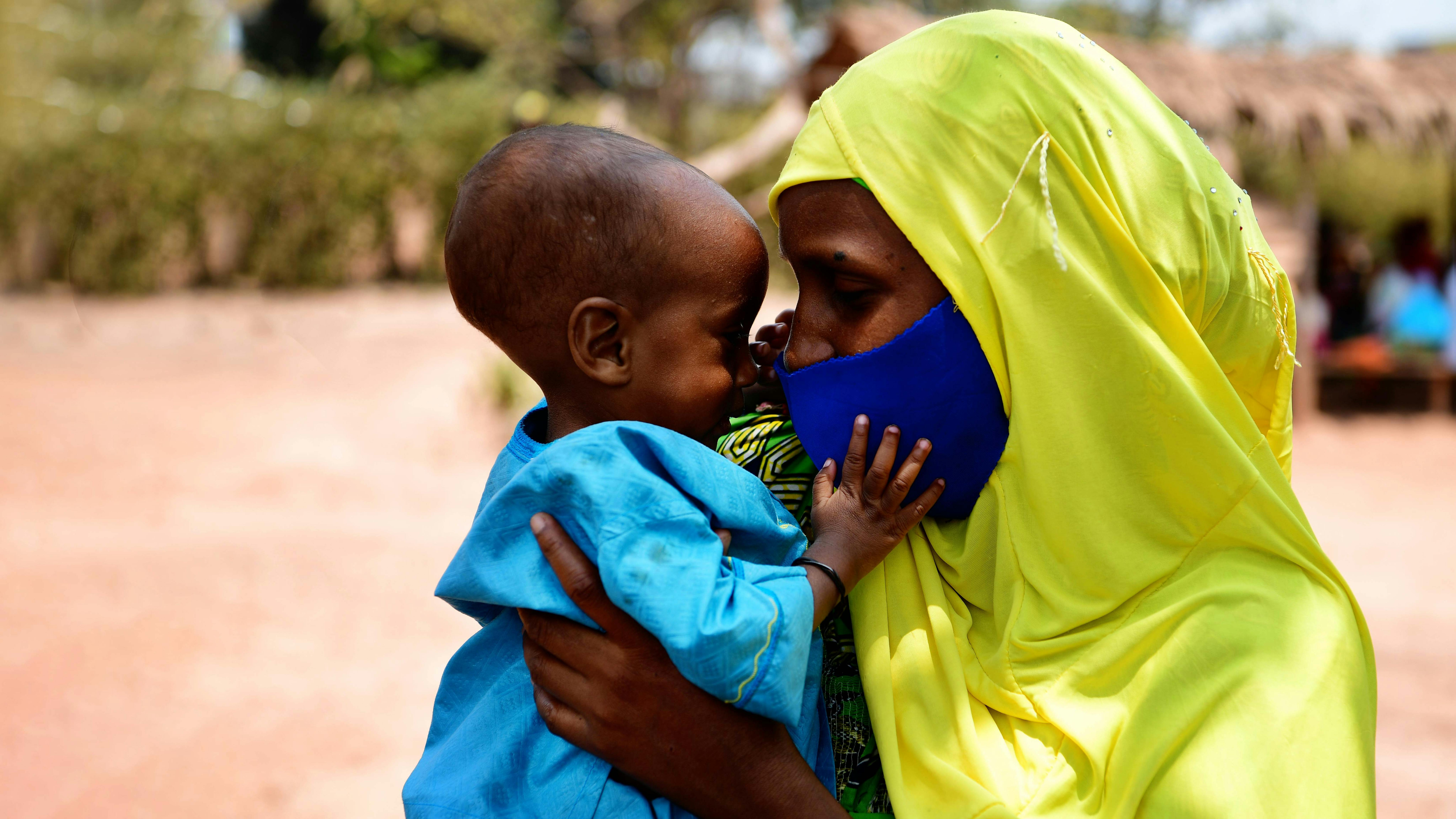 Camerun, un bambino gioca con sua mamma durante una incontro di comunità