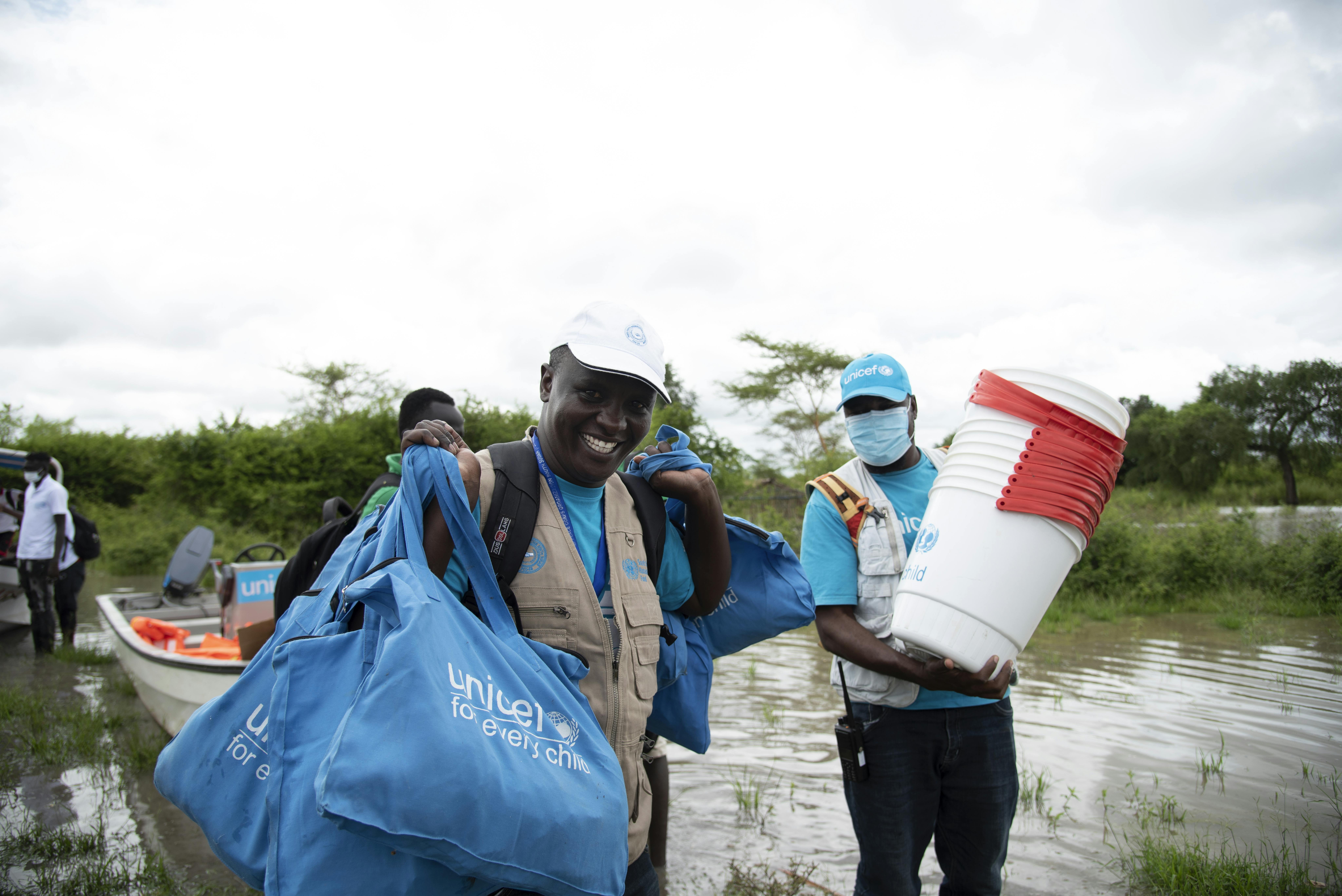Gli specialisti dell'emergenza dell'UNICEF trasportano secchi per la purificazione dell'acqua e altre forniture di emergenza, inclusi kit per l'igiene, da distribuire lungo il fiume Pibor, straripato, in Sud Sudan.