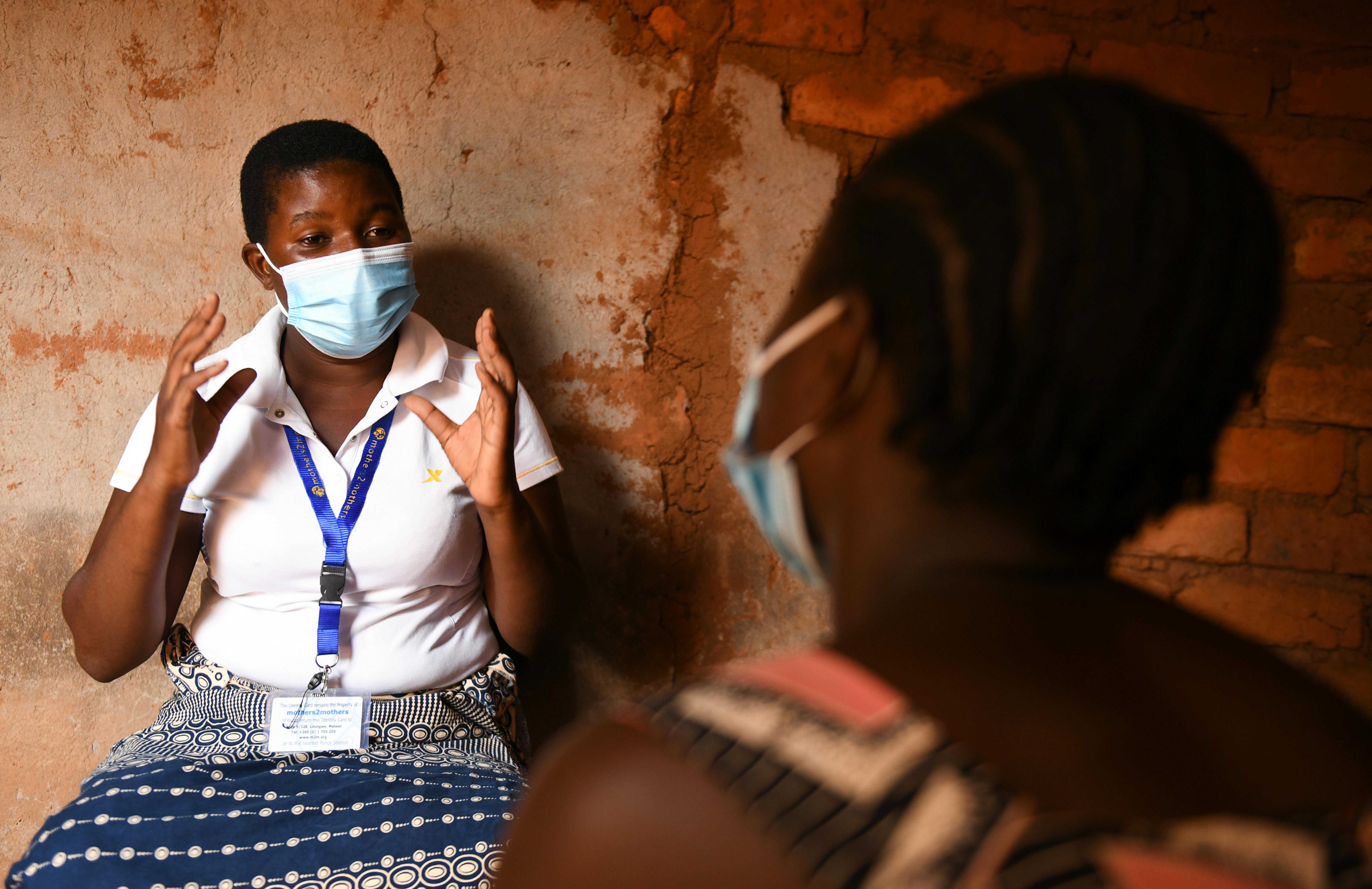 Awema, (in bianco) una madre mentore per giovani donne sieropositive, parla con Florence, una mamma adolescente, al Maliyela Village a Mulanje Malawi