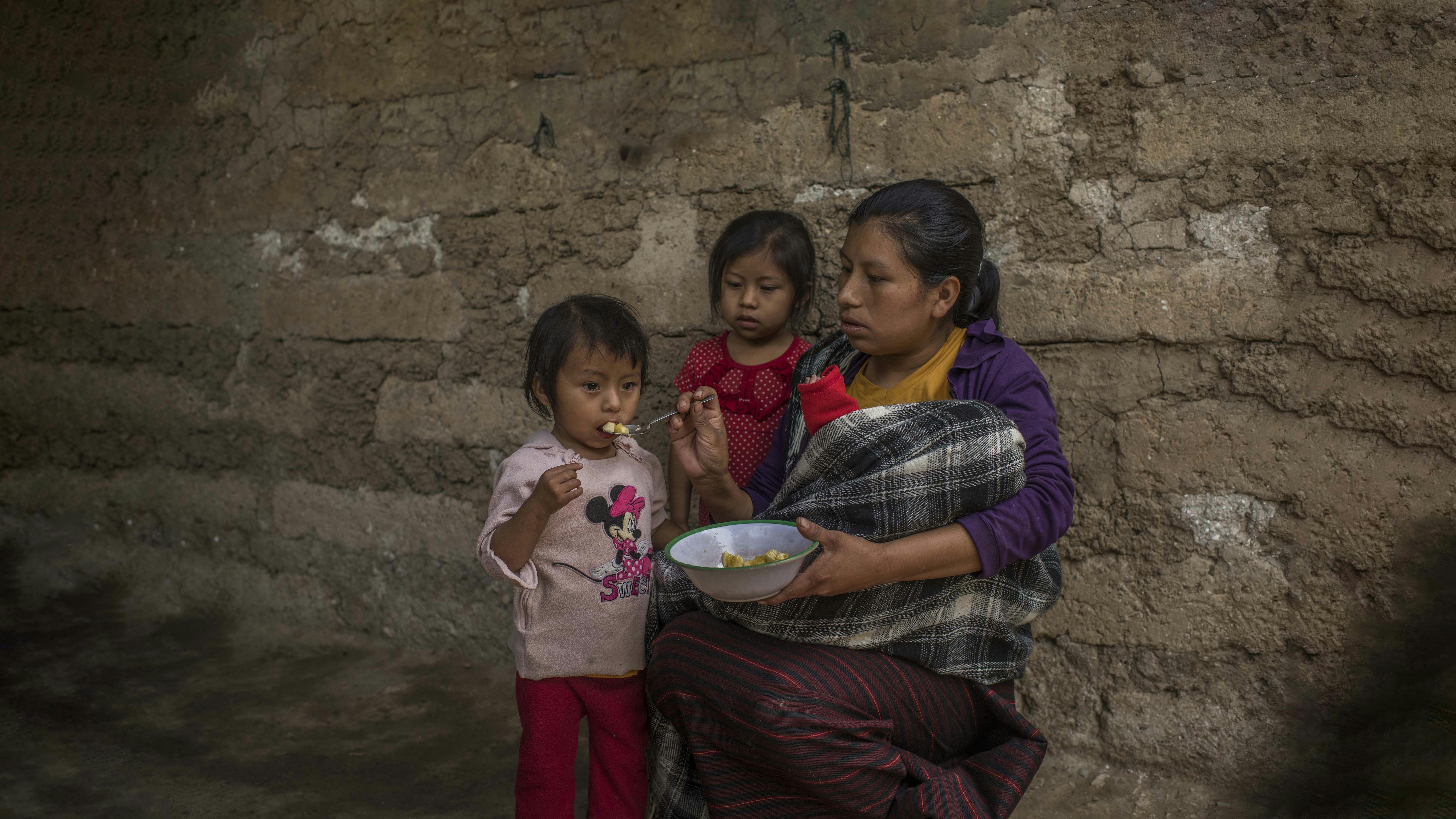 Guatemala - Maria sta dando da mangiare banane schiacciate a sua figlia Mariela.