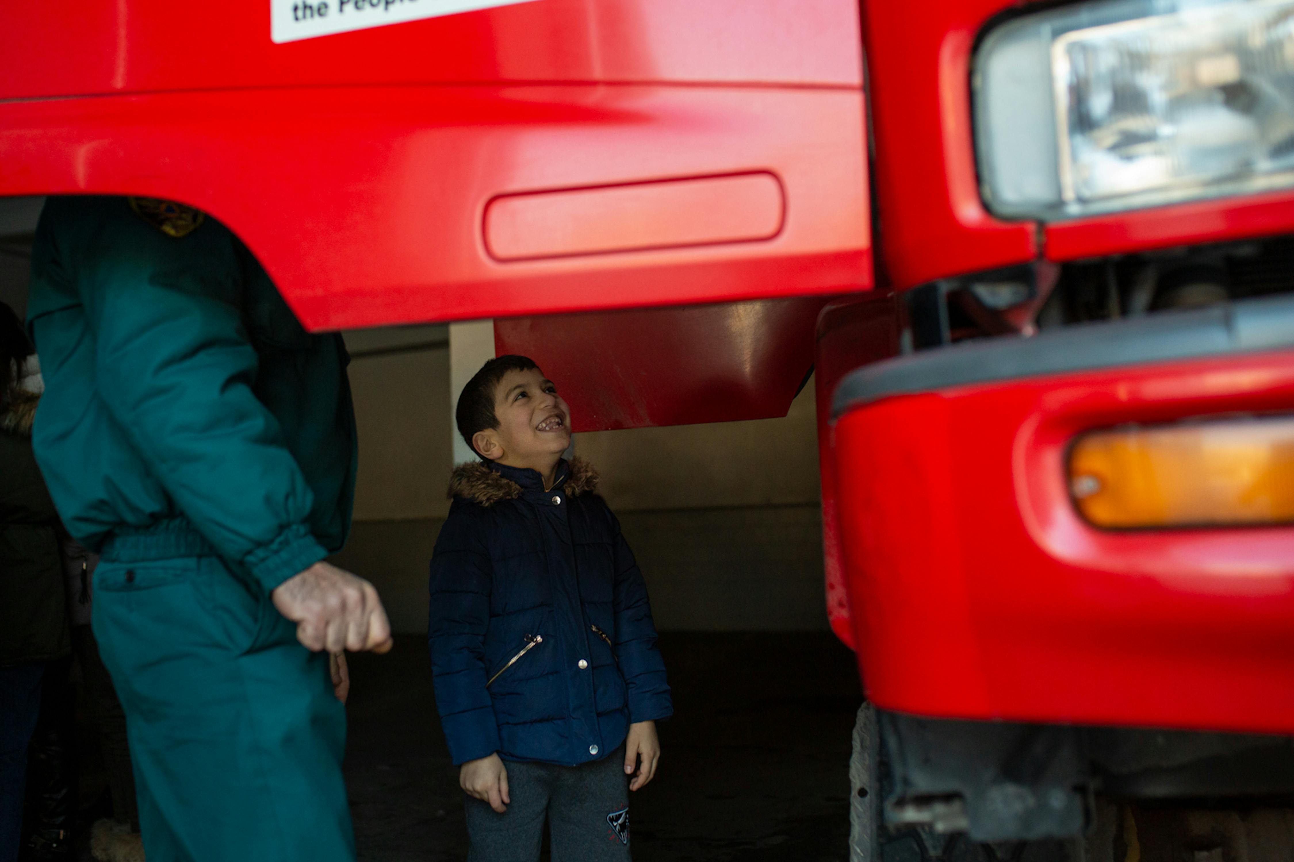 Armenia, David, 6 anni, osserva un camion dei pompieri. Da grande vorrebbe diventare un Vigile del Fuoco per salvare le persone