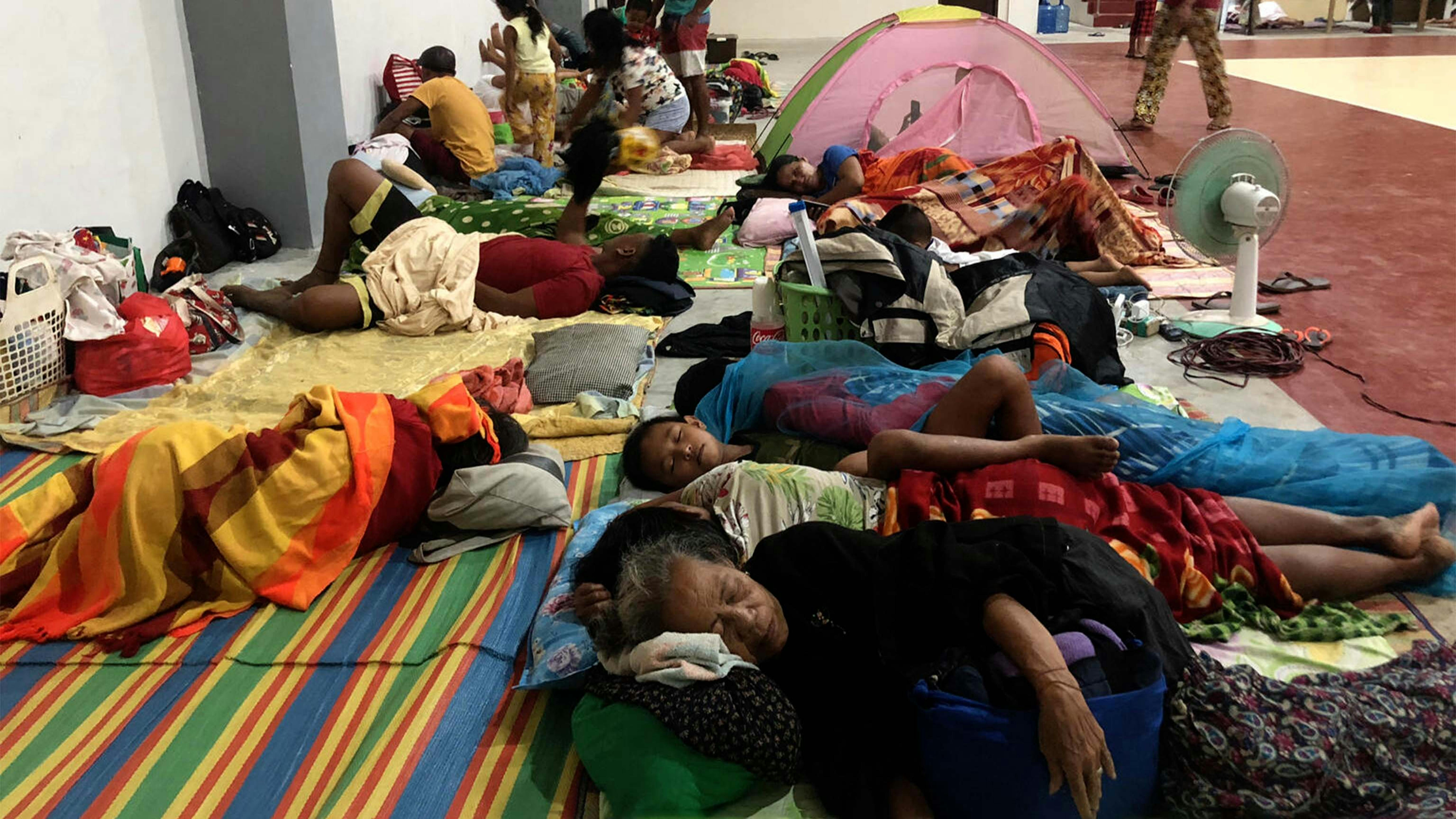 i residenti dormono all'interno di un complesso sportivo trasformato in un centro di evacuazione nella città di Dapa, sull'isola di Siargao