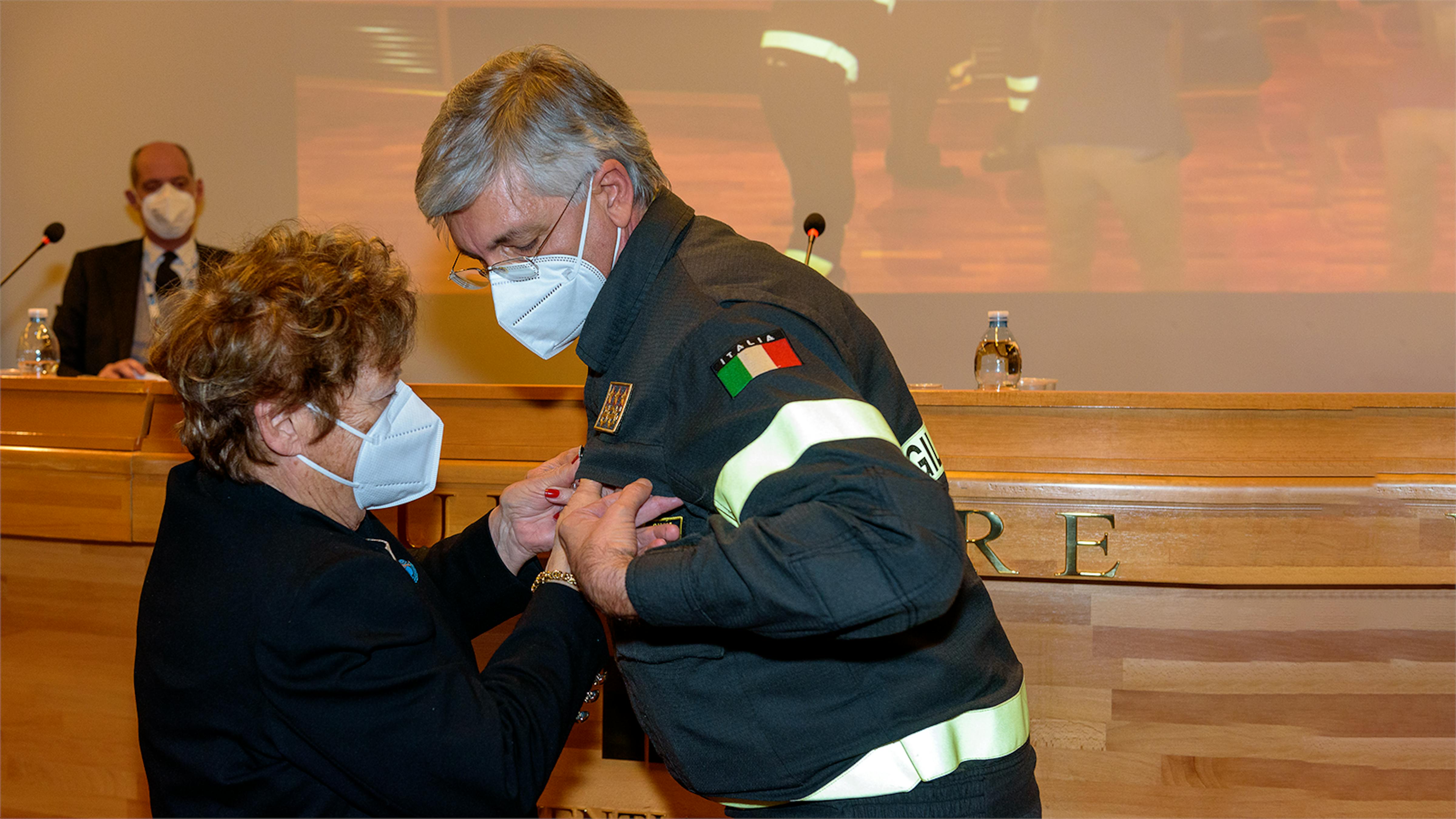 La Presidente dell'UNICEF Carmela Pace appunta la spilla dell’UNICEF sulla divisa del Capo del Corpo Nazionale dei Vigili del Fuoco Guido Parisi