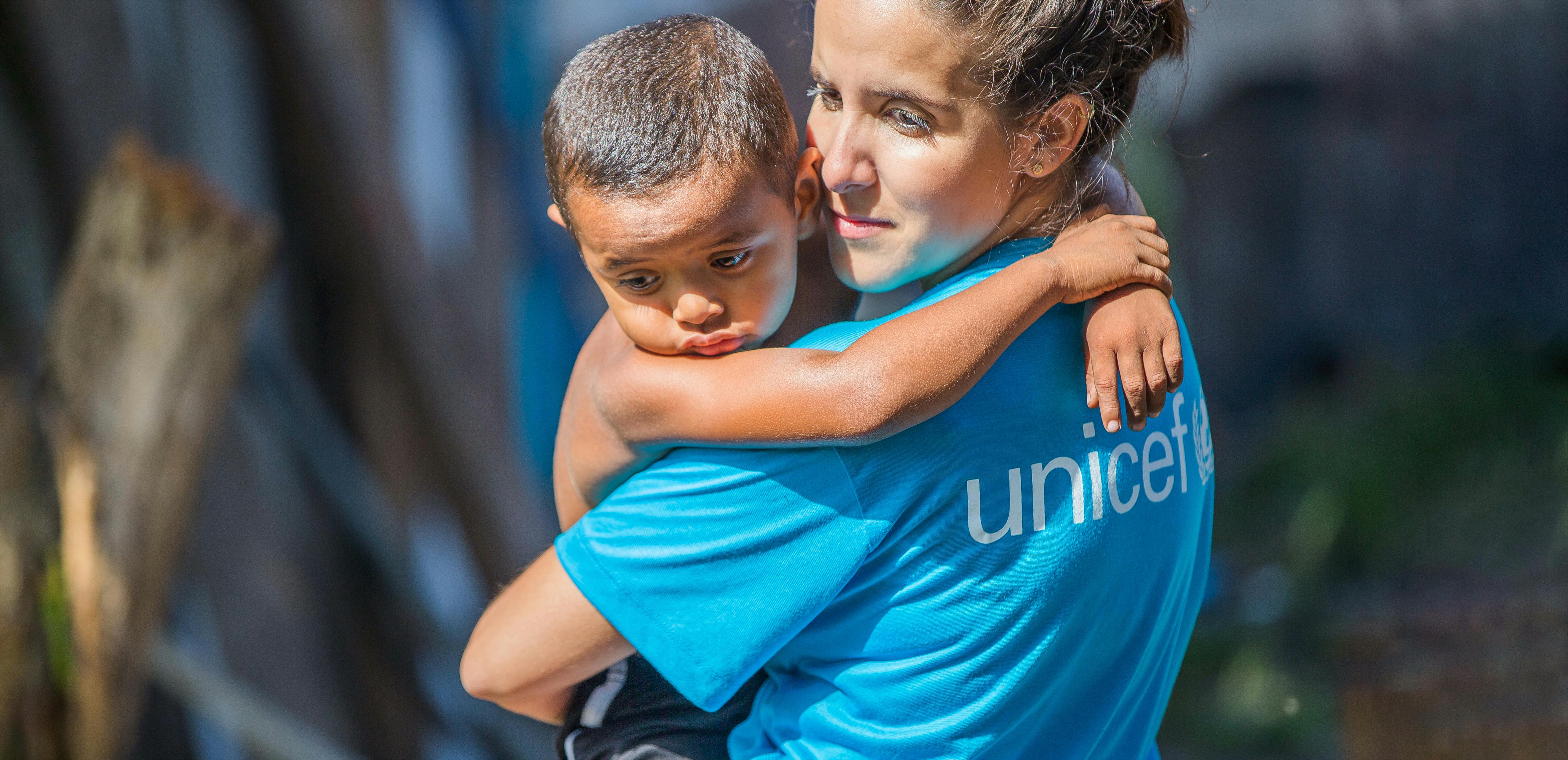 Brasile, lidia  un operatrice UNICEF tiene in braccio un bambino