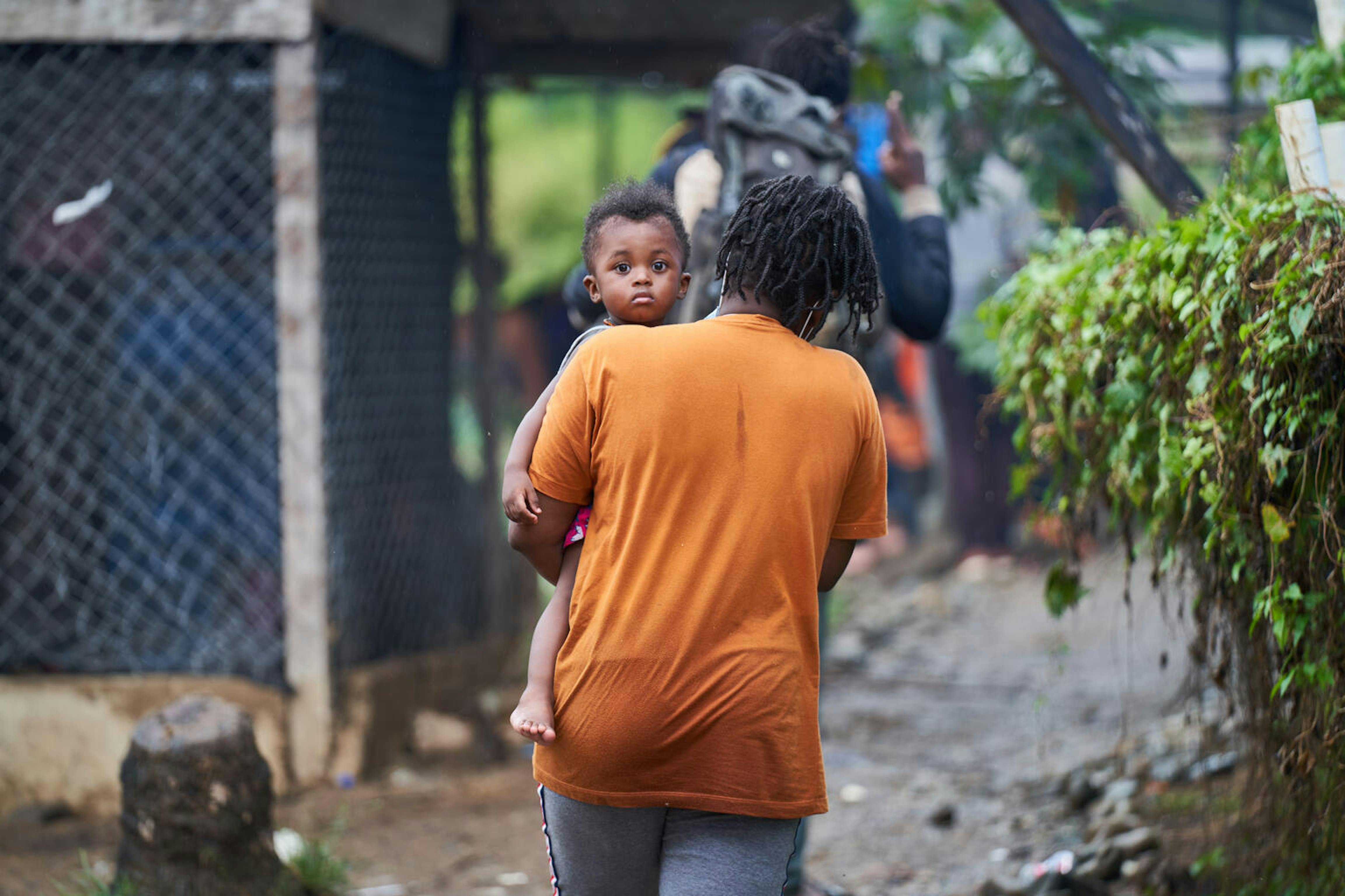 Una donna porta in braccio un bambino nel centro di accoglienza per migranti a Bajo Chiquito, Panama.
