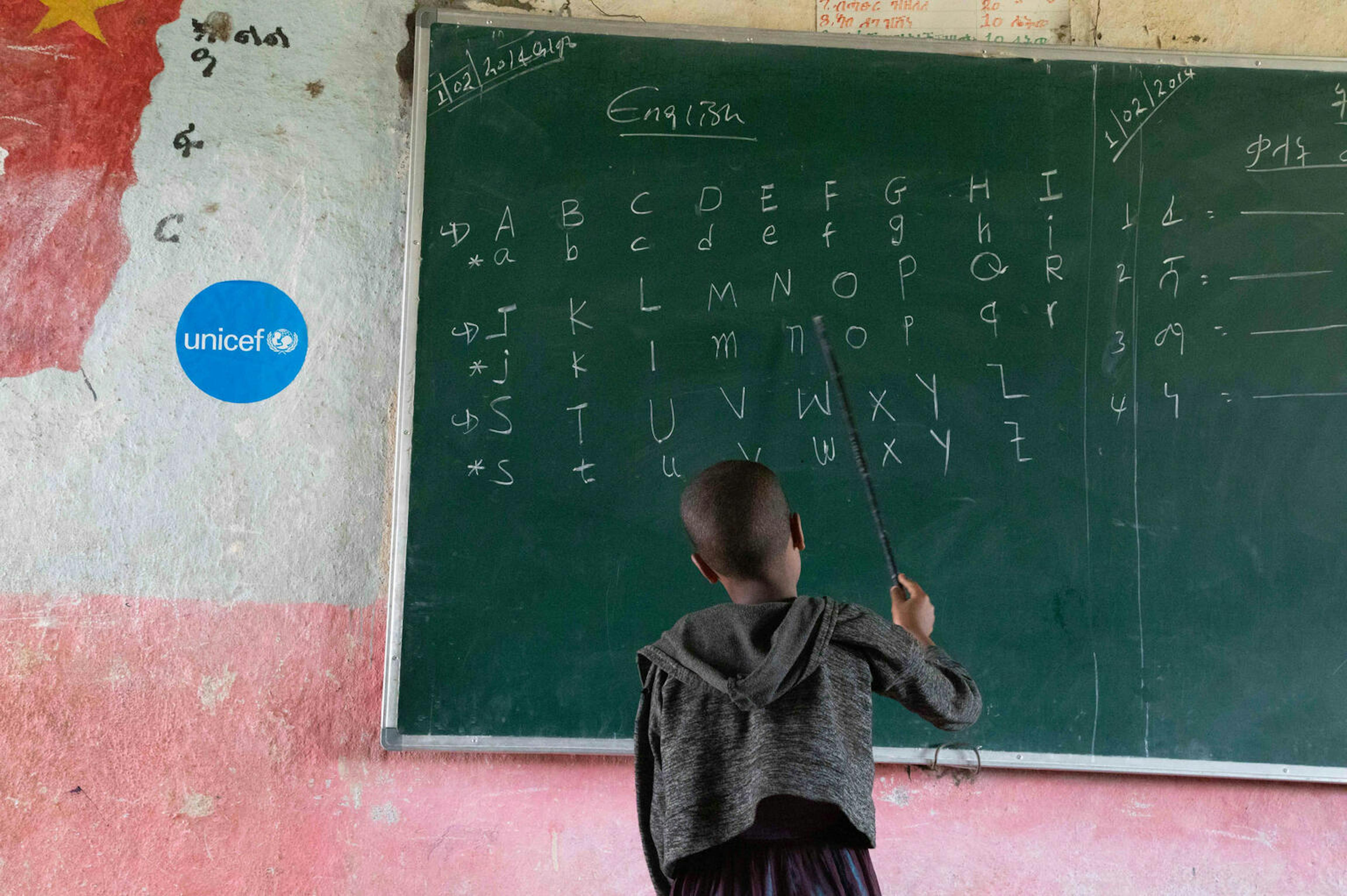 Un bambino scrive alla lavagna in una scuola supportata dall'UNICEF ad Adikeyeh, nella regione centrale del Tigrai, in Etiopia. Molti bambini a causa del Covid-19 e del conflitto in corso nella regione non sono potuti tornare a scuola