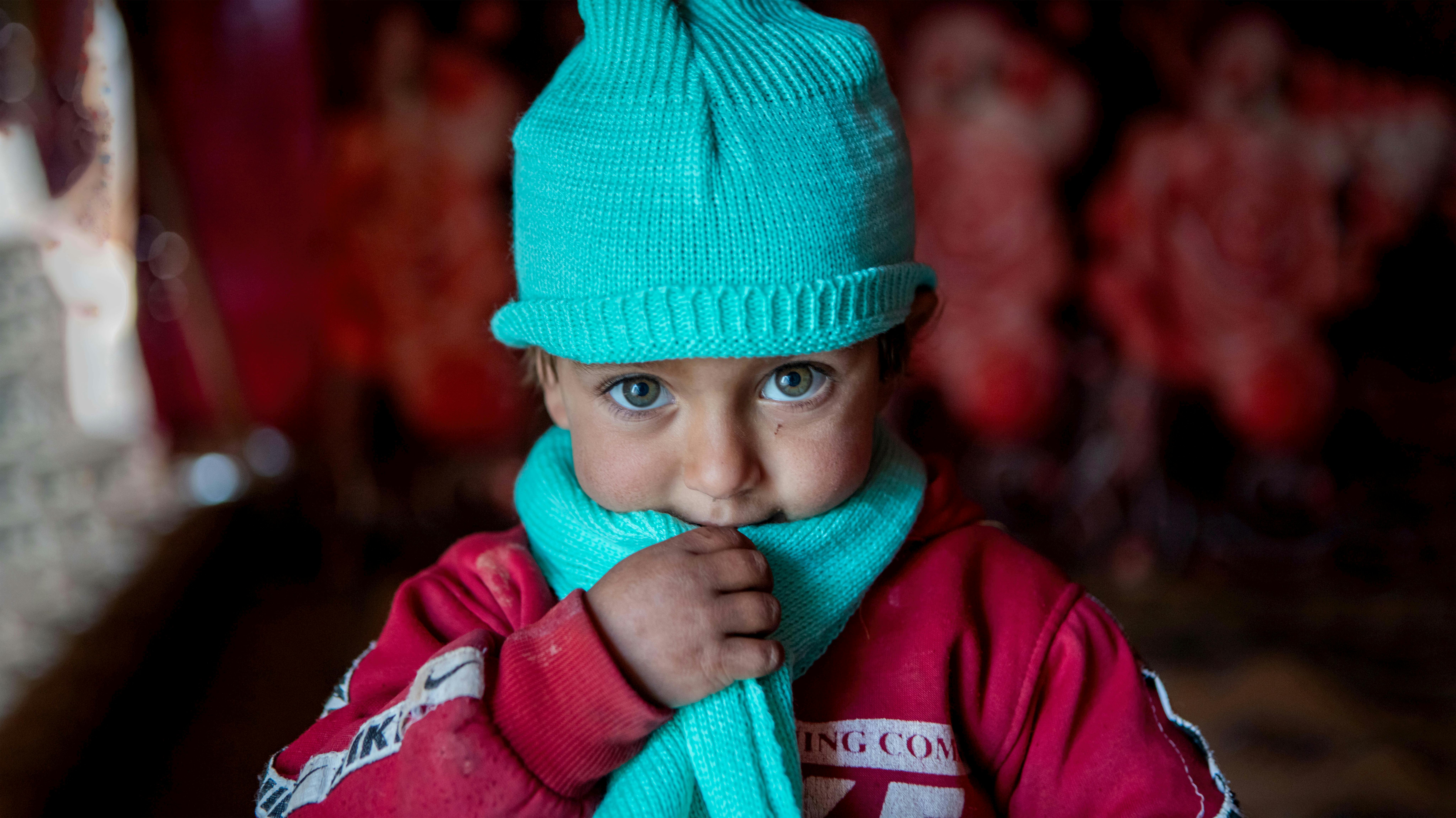 La piccola Kawthar, 3 anni, indossa sciarpa e cappello di lana, consegnati dall’UNICEF insieme al resto del kit di abiti invernali. Siamo in Siria, nel villaggio di Alzhouriyeh, zona rurale orientale di Homs