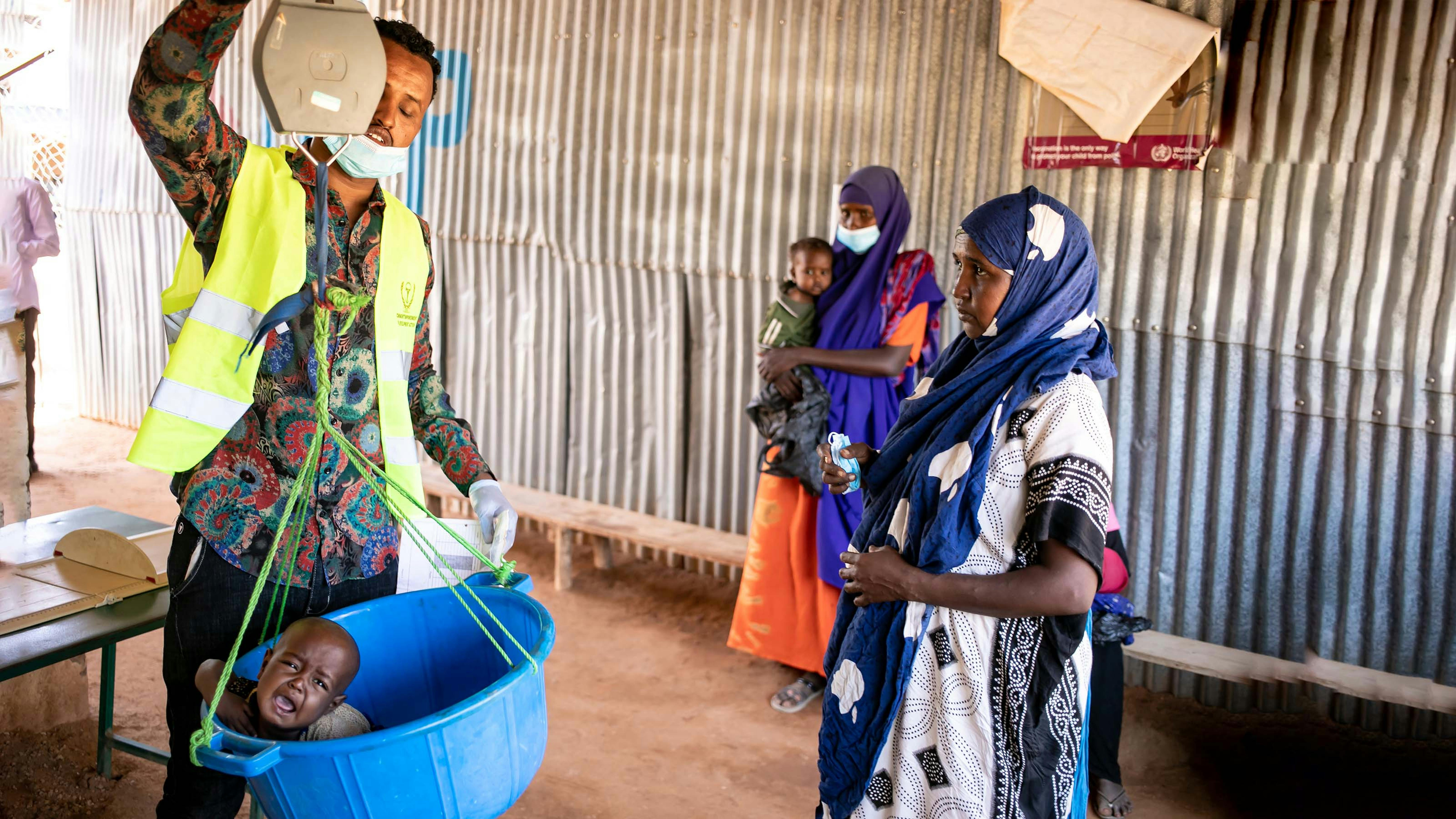 Somalia, Dahiro Hassan, 33 anni, osserva il medico che pesa sua figlia al Dolow Health Center di Dolow