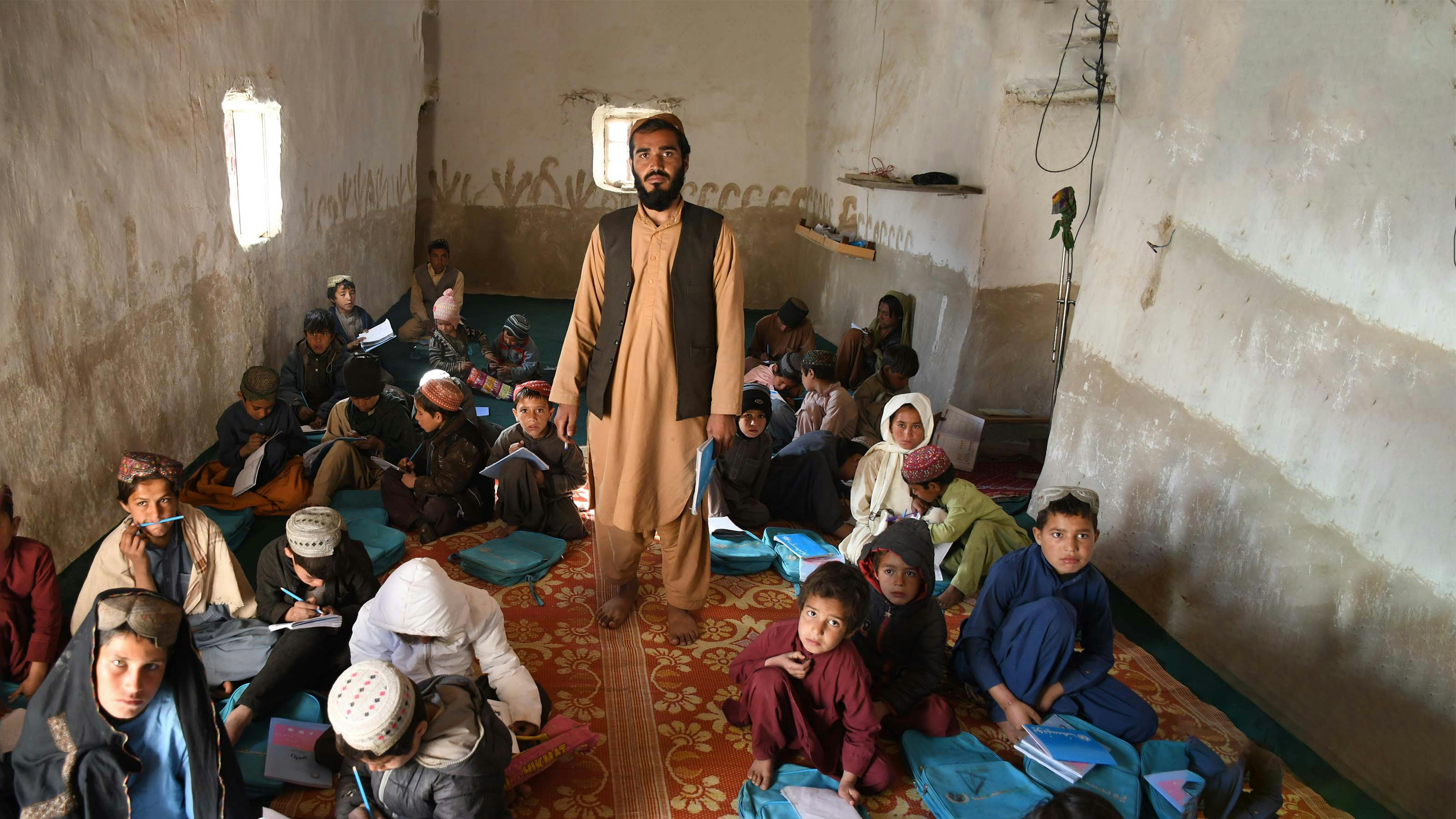 Afghanistan, un insegnante in classe con gli alunni della scuola del villaggio di Shurandam, Kandahar.