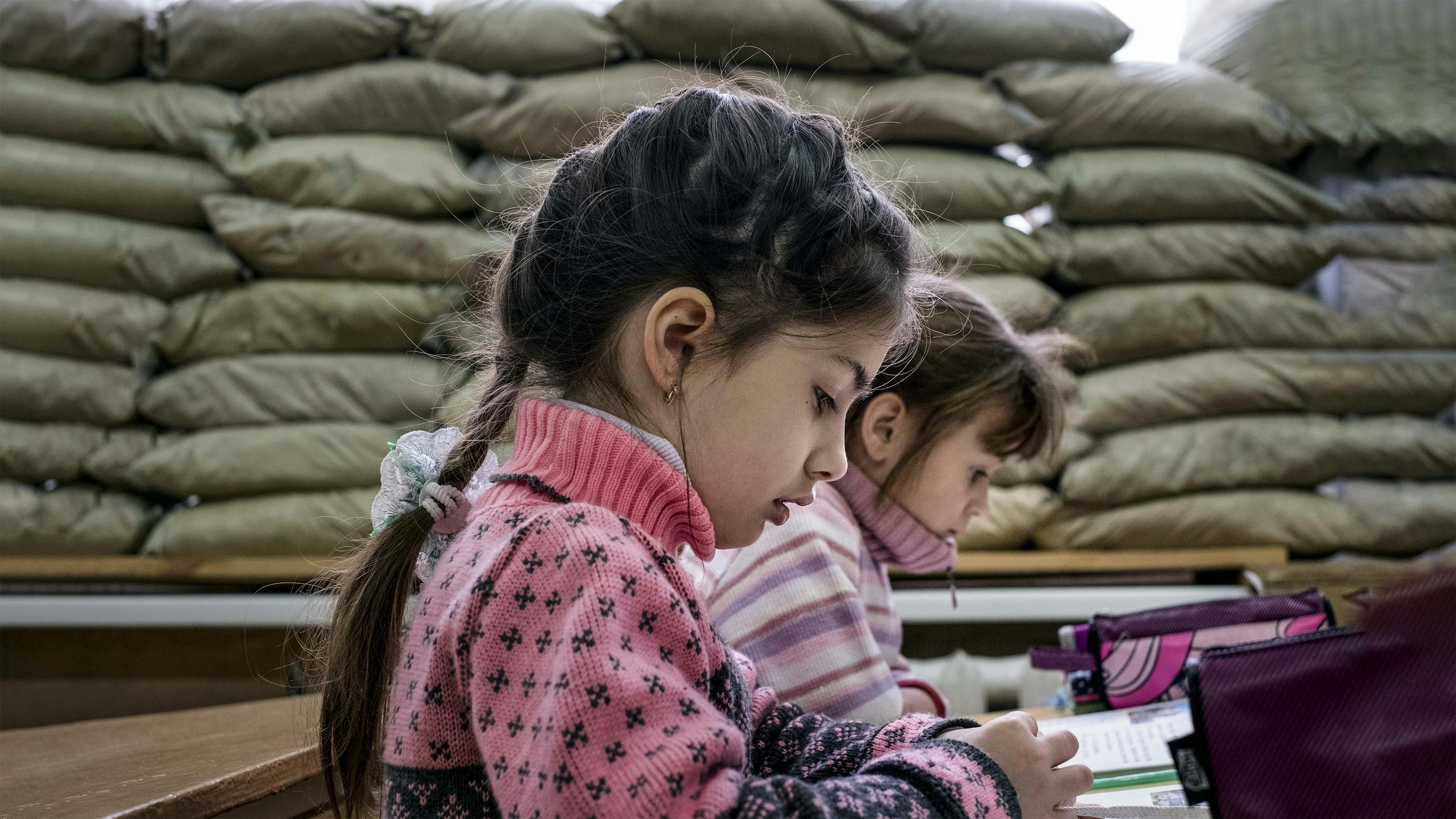 Ucraina, Gli alunni di prima elementare della scuola di Mariinka siedono in un'aula dove le finestre sono state ricoperte con sacchi di sabbia