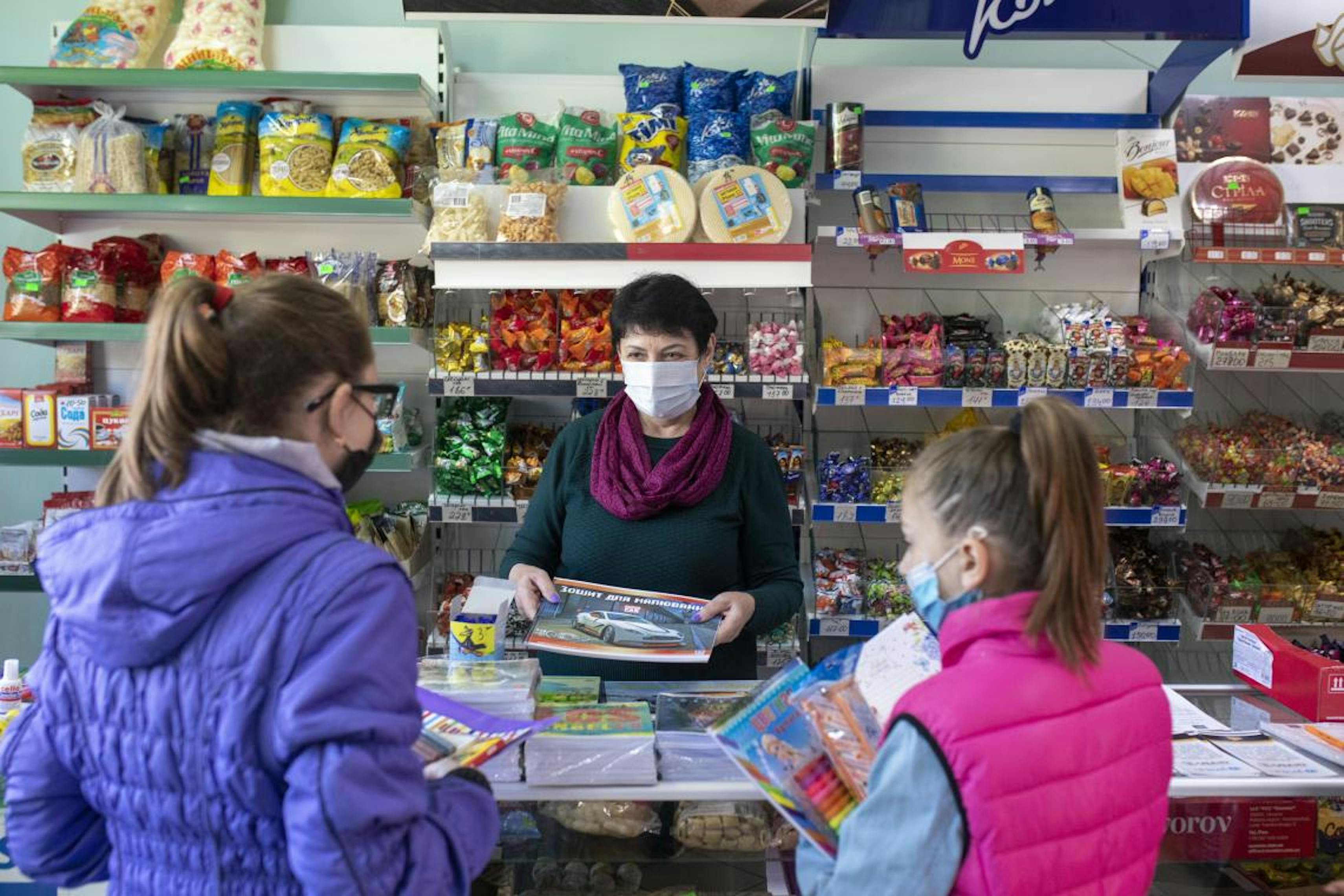 Tetiana, negoziante di una piccola bottega di Hranitne, in Ucraina Orientale, vende articoli di cancelleria alle due bambine