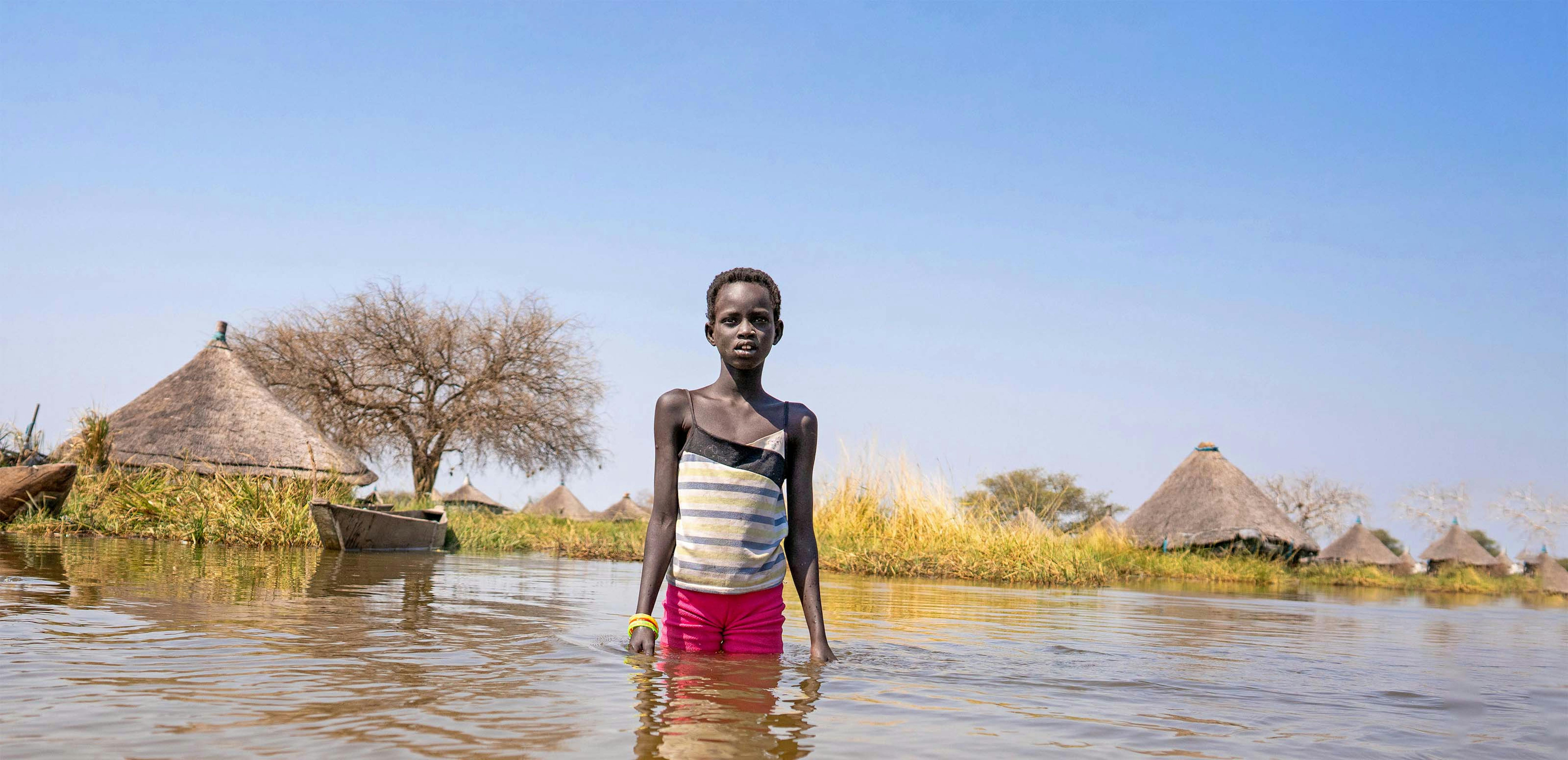 Sud Sudan - Alekiir Deng Lueth lava le pentole nell'acqua alluvionale fuori dal villaggio di Panyagor a Twic East