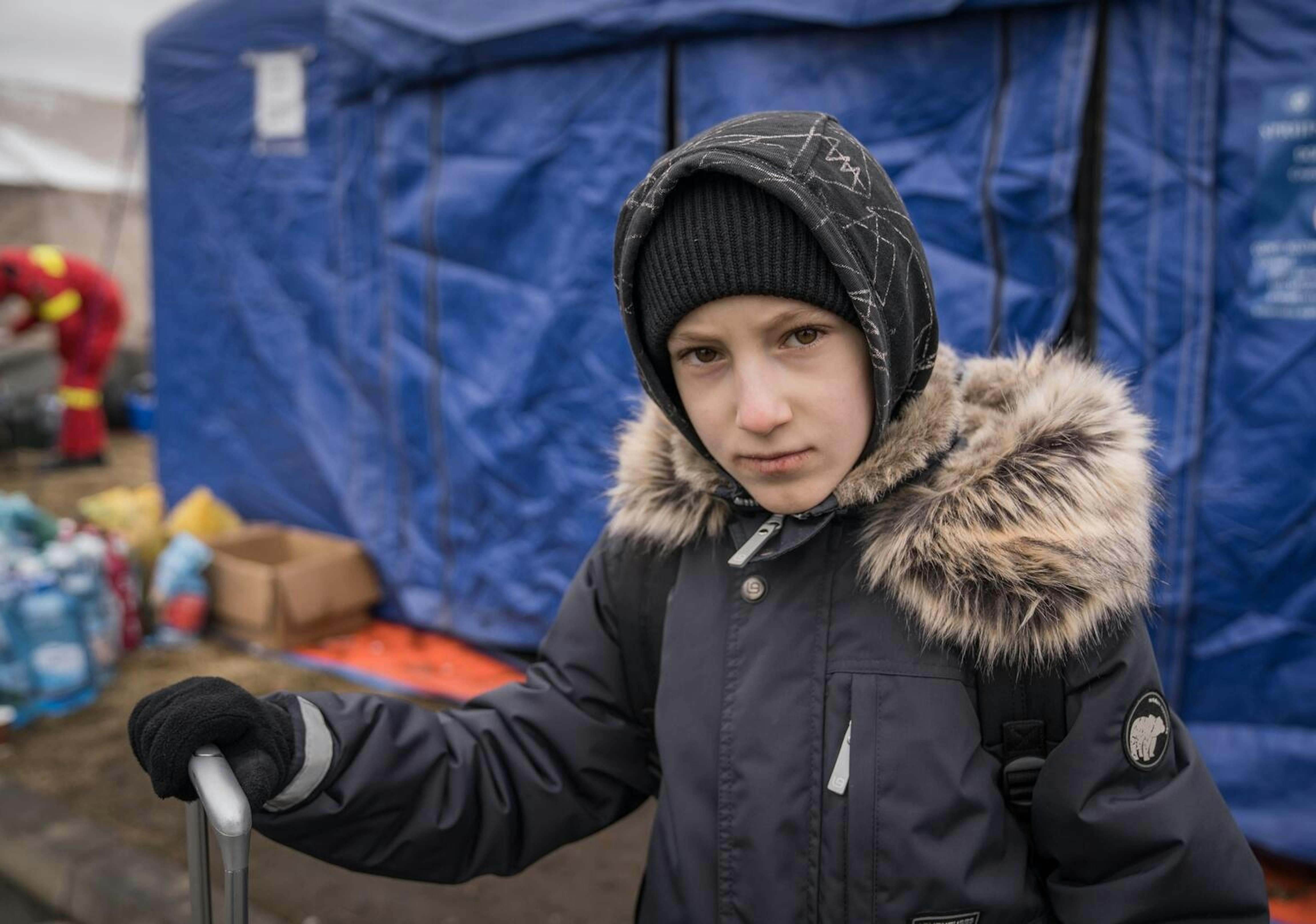 Yaroslav, in piedi con una valigia con le sue cose, si trova vicino al confine tra Ucraina e Romania. Ha compiuto questo viaggio con sua madre, Vica
