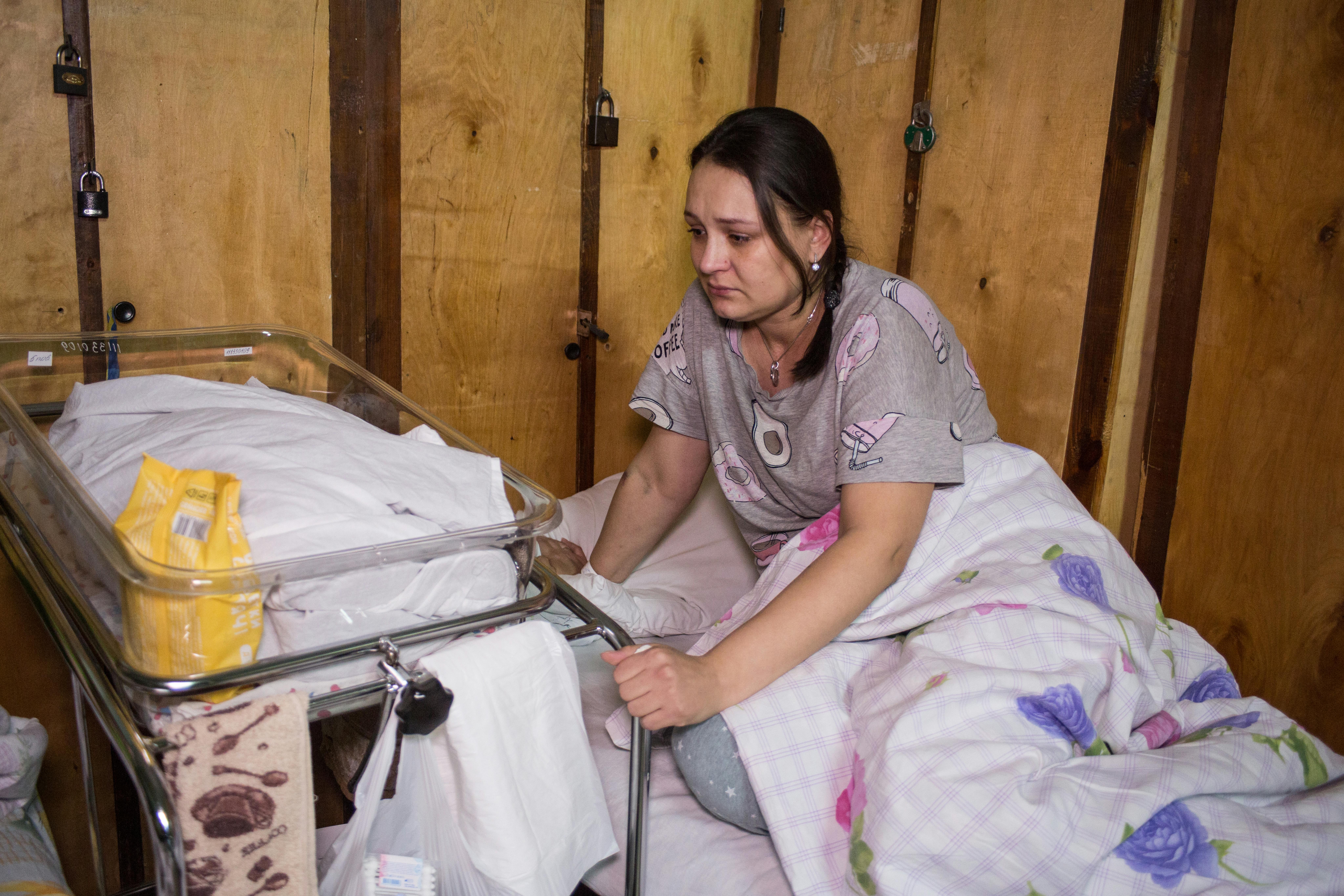 Una mamma visibilmente provata culla il suo bambino. Da quando il conflitto si è intensificato, le famiglie si sono rifugiate sottoterra, tagliate fuori dai servizi di base. Ospedali e reparti di maternità hanno spostato i loro pazienti negli scantinati o stanno operando sotto il fuoco incrociato. La situazione è drammatica per i reparti maternità in città come Kiev, Odesa e Kharkiv, dove i combattimenti continuano a colpire civili e ospedali.