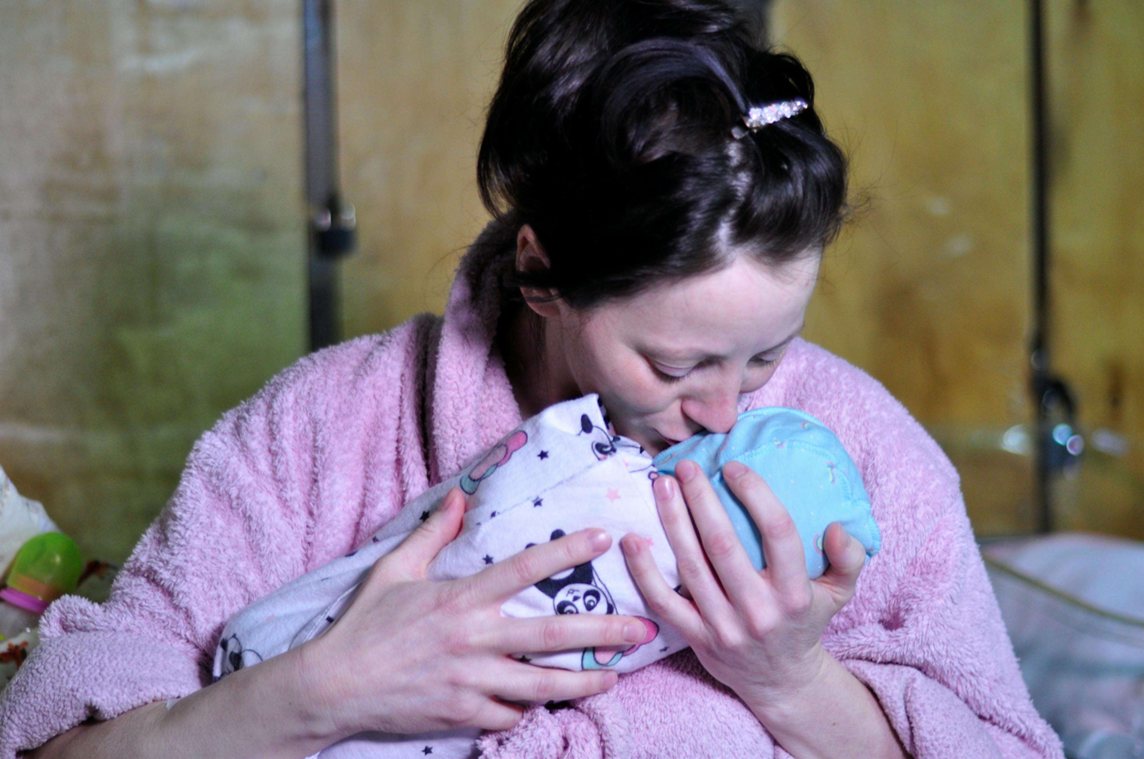 Ucraina: una mamma bacia il suo piccolo appena nato. Il conflitto scoppiato nel febbraio 2022 ha messo a rischio milioni di civili, tra cui mamme incinte e bambini appena nati.