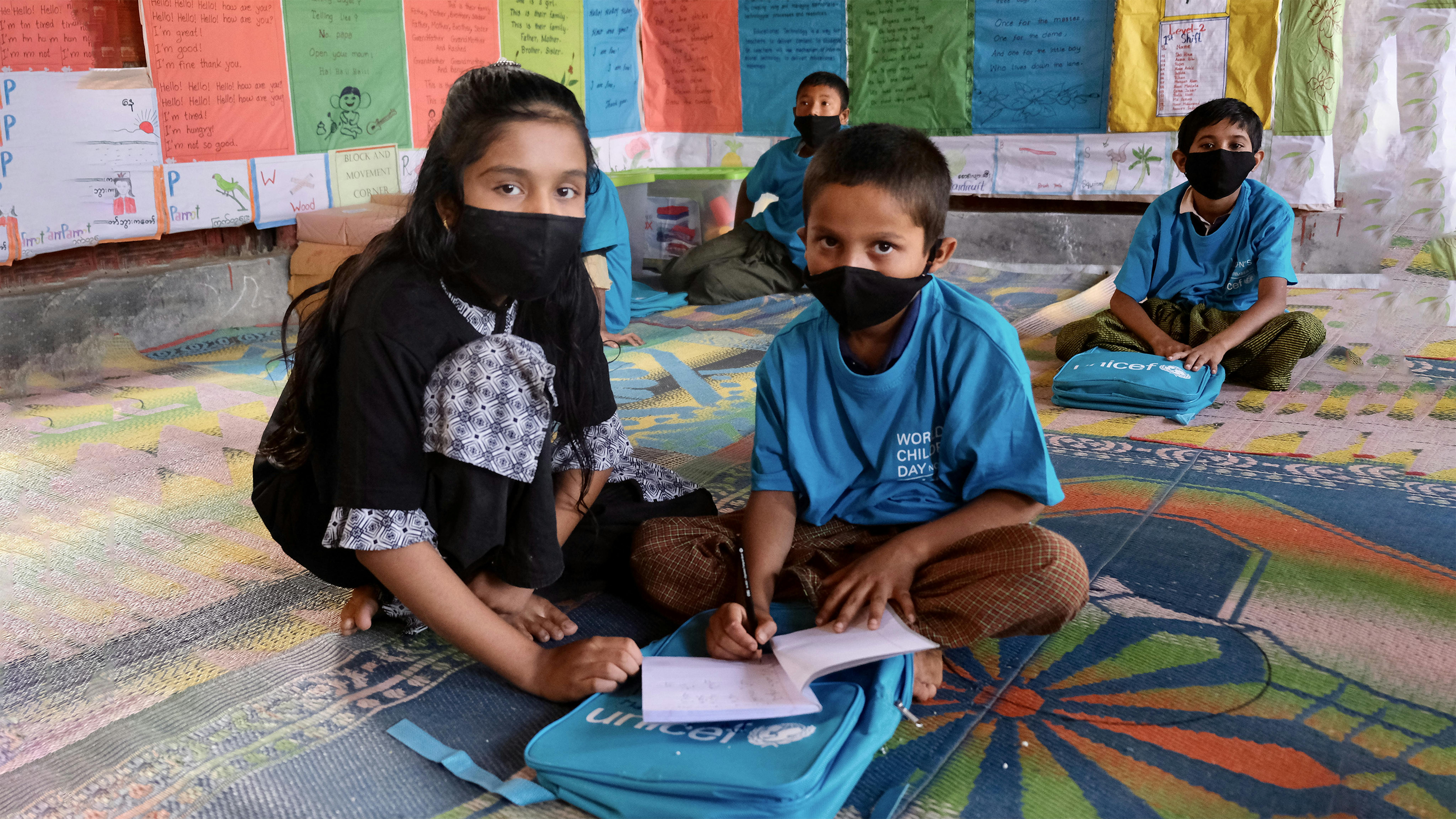 Bangladesh, Bushara, 10 anni, aiuta gli studenti più piccoli a risolvere un compito durante il Kids Takeover in uno dei campi profughi Rohingya.