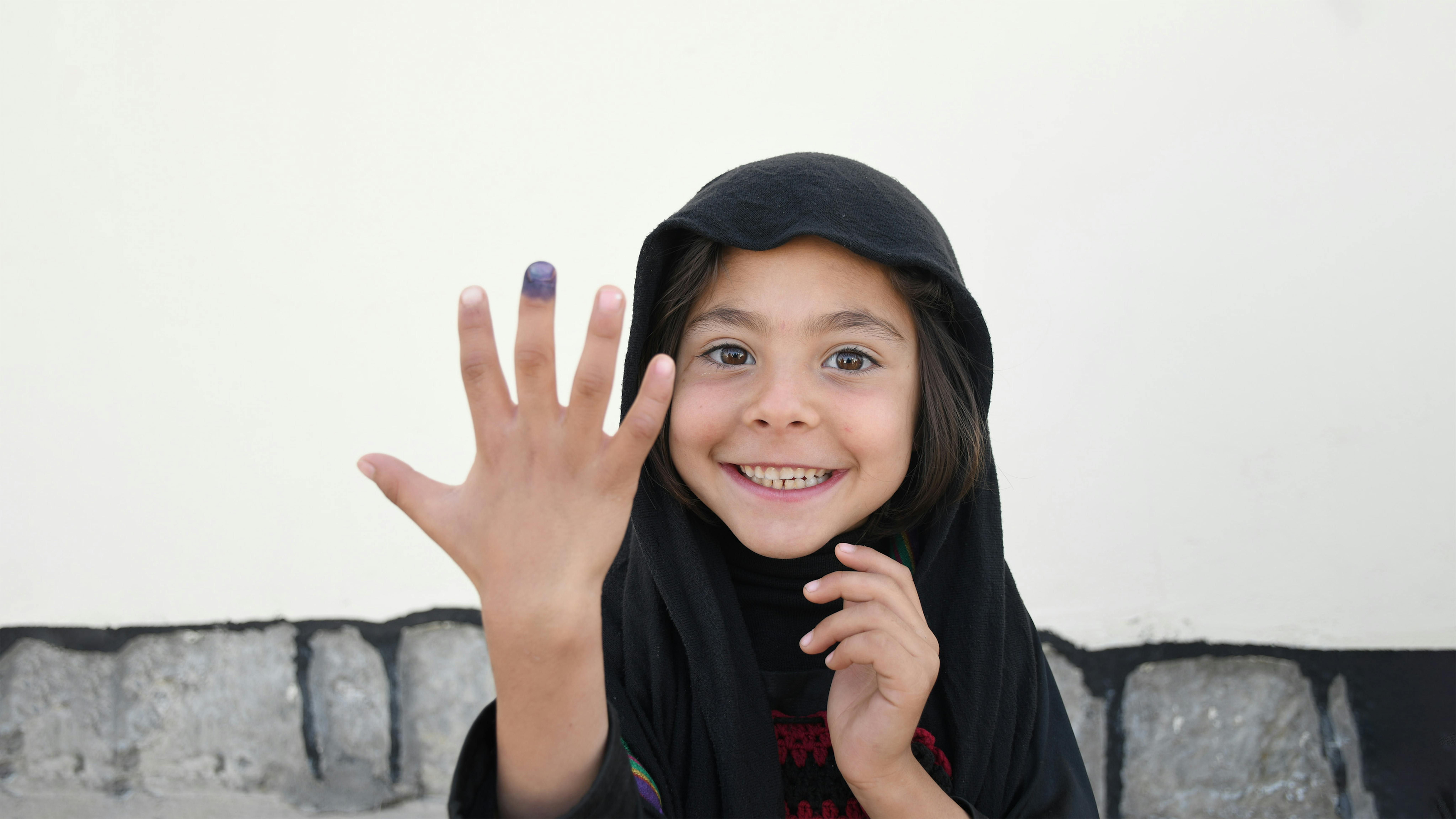 Afghanistan, una bambina mostra il suo marchio di vaccinazione alla clinica Mir Bazar.