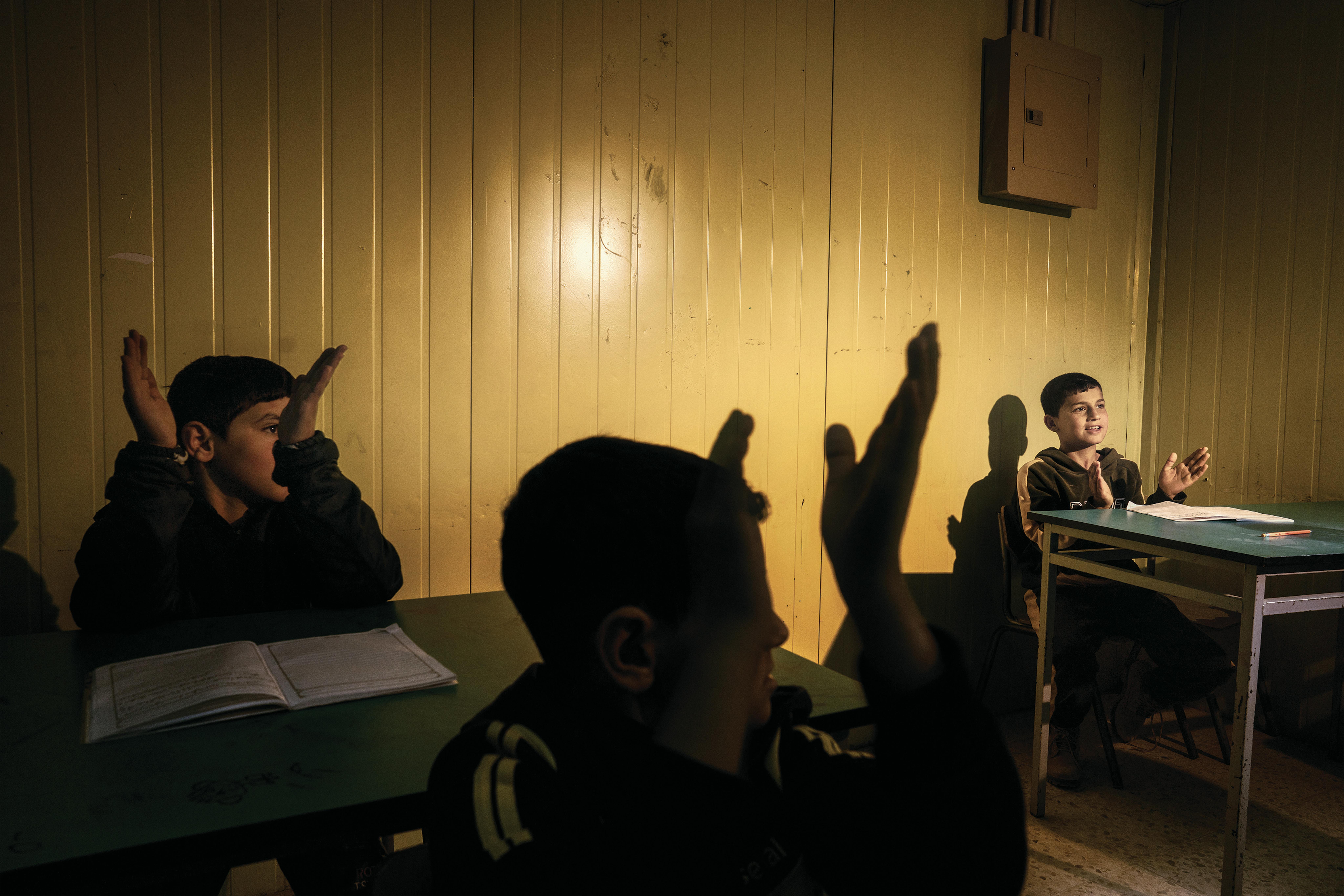 Bambini battono le mani durante una lezione nel campo profughi di Zaatari.