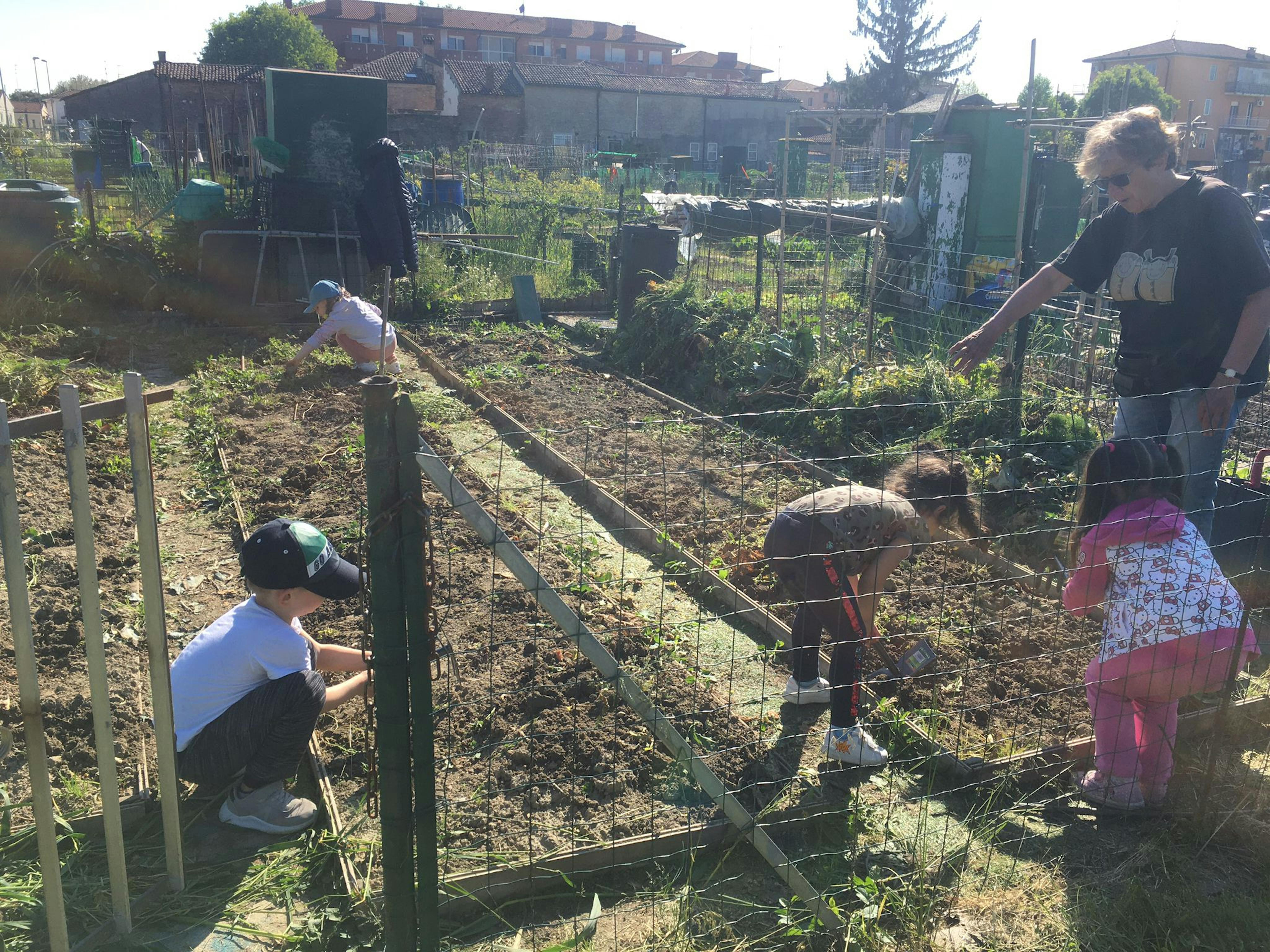 Alcuni bambini zappano la terra, sotto la supervisione di una mediatrice. Il laboratorio orto, organizzato da UNICEF Ferrara, che ha coinvolto  i bambini ucraini che hanno seminato, zappato, estirpato e raccolto ortaggi sia presso orti cittadini, che musei, giardini, spazi urbani. 