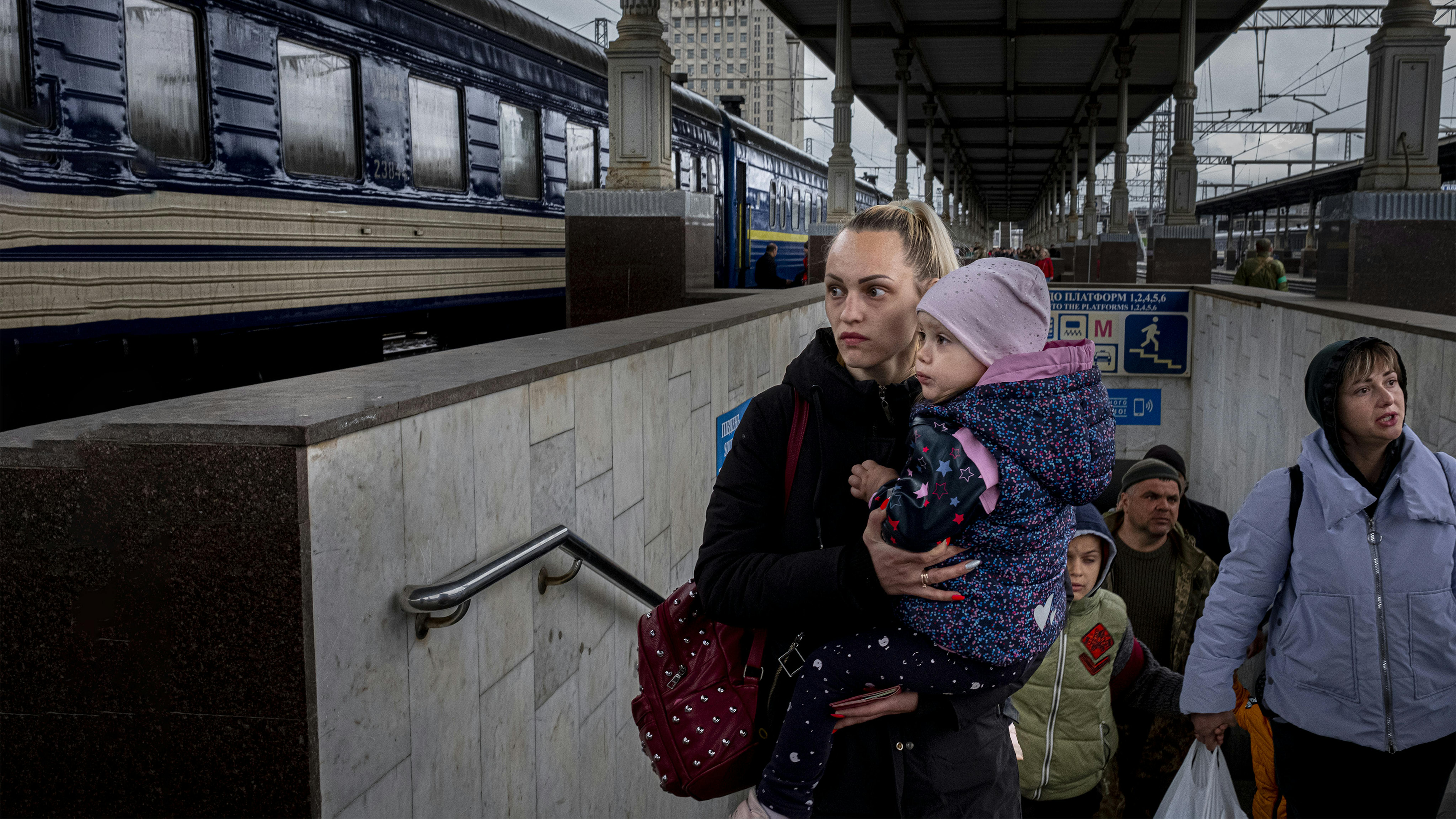 A Kharkiv, in Ucraina, una donna con un bambino in braccio va a prendere un treno speciale per lasciare la città.